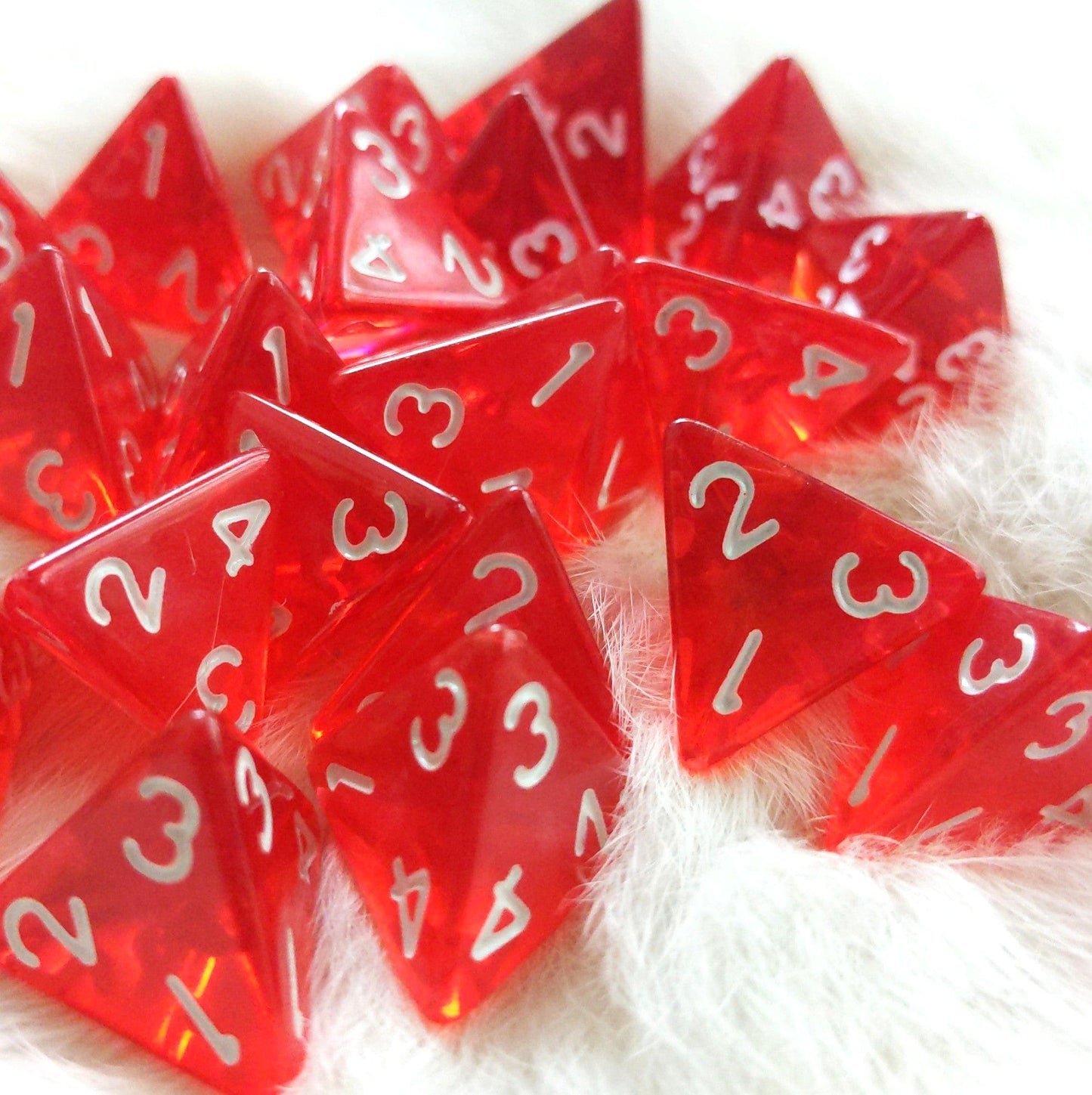 Translucent red D4 dice set for Dungeons and Dragons healing potions on white background.