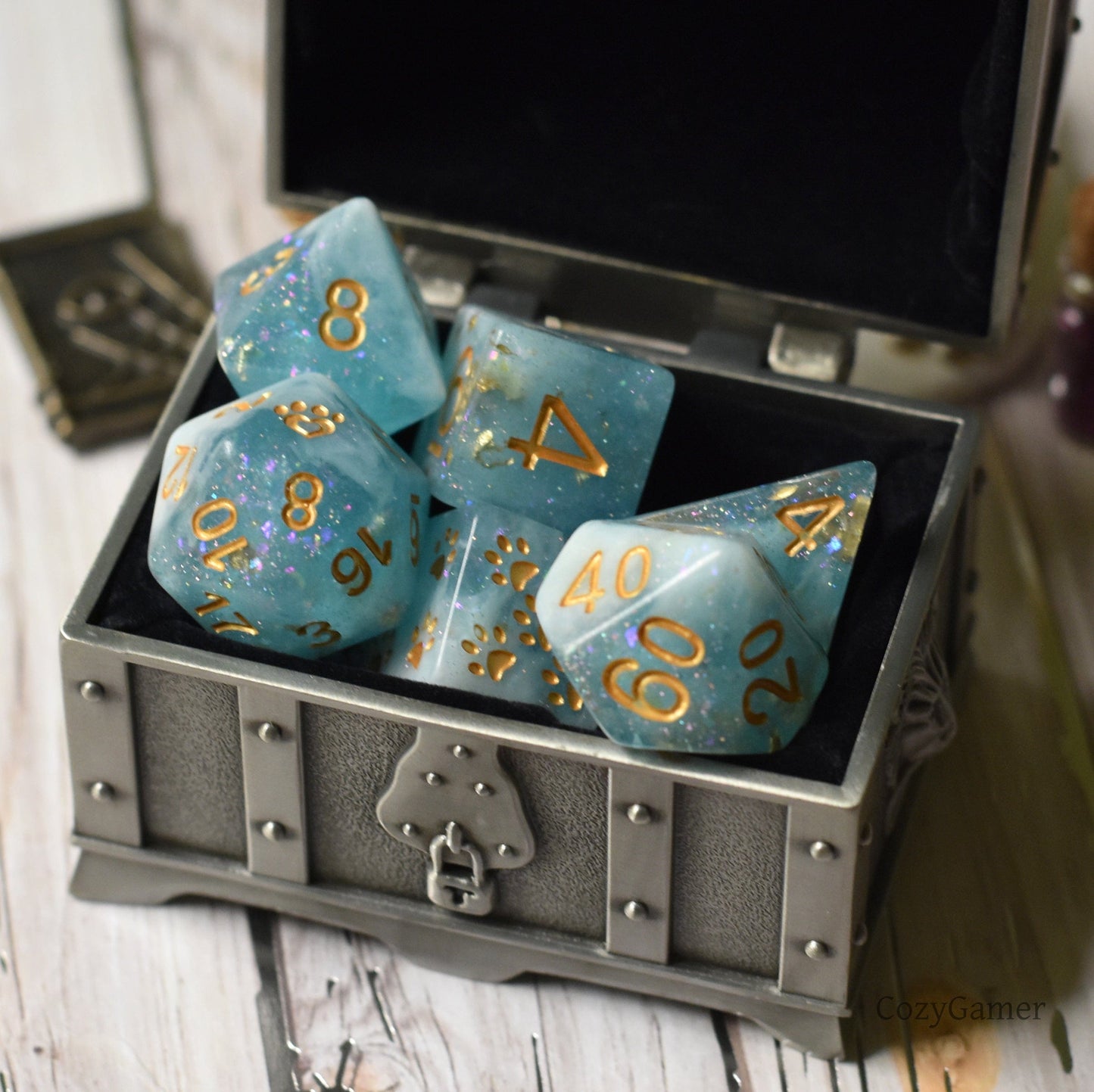 Cresting Wave 8 piece DnD dice set in a treasure chest, featuring glittery blue resin with gold numbers, custom cat wizard design.