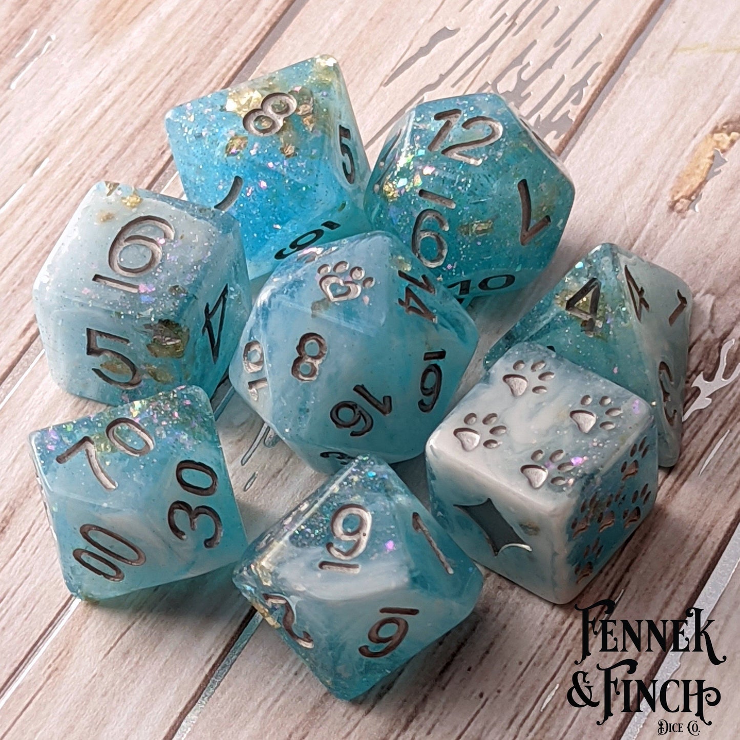 Cresting Wave 8 Piece DnD Dice Set in clear blue resin with glitter, featuring cat wizard and paw designs, for tabletop RPGs.