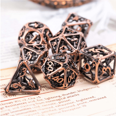Cross Bones Hollow Metal Dice Set with intricate polyhedral design for tabletop RPGs displayed on a game manual.