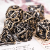 Hollow metal dice set with cross bone design for tabletop role-playing games like Dungeons and Dragons.