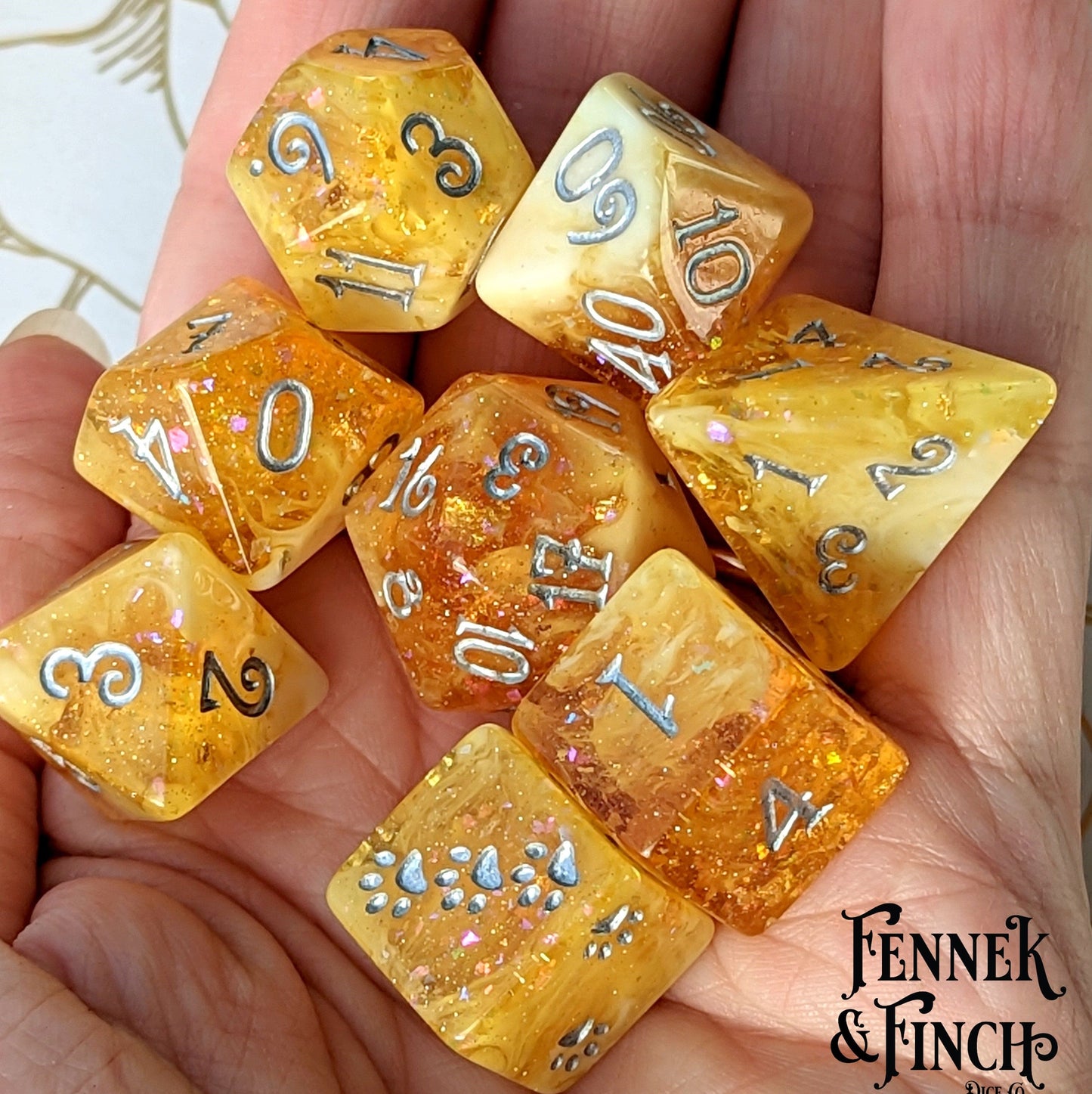 Crystallized Honey 8 Piece Dice Set in clear orange and white marble with glitter and foil, featuring unique cat paws design.