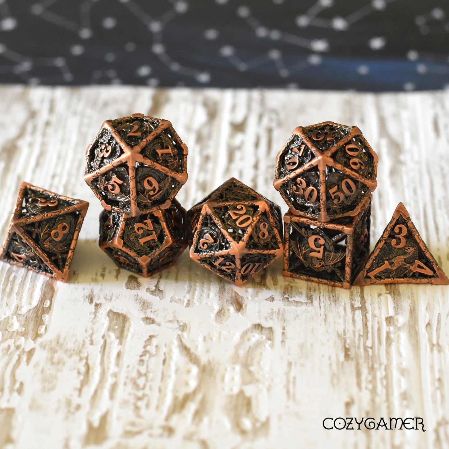 Dragon and Shield hollow metal dice set, 7-piece polyhedral for tabletop RPGs, featuring intricate design and unique sound.