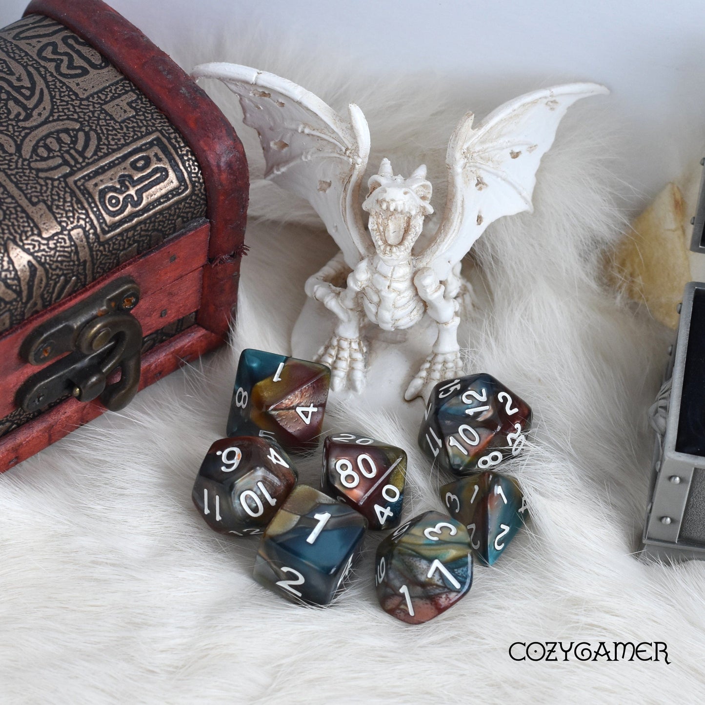 Earthen Ring Marble Dice Set and dragon figurine beside treasure chest, perfect for TTRPGs like Dungeons and Dragons.
