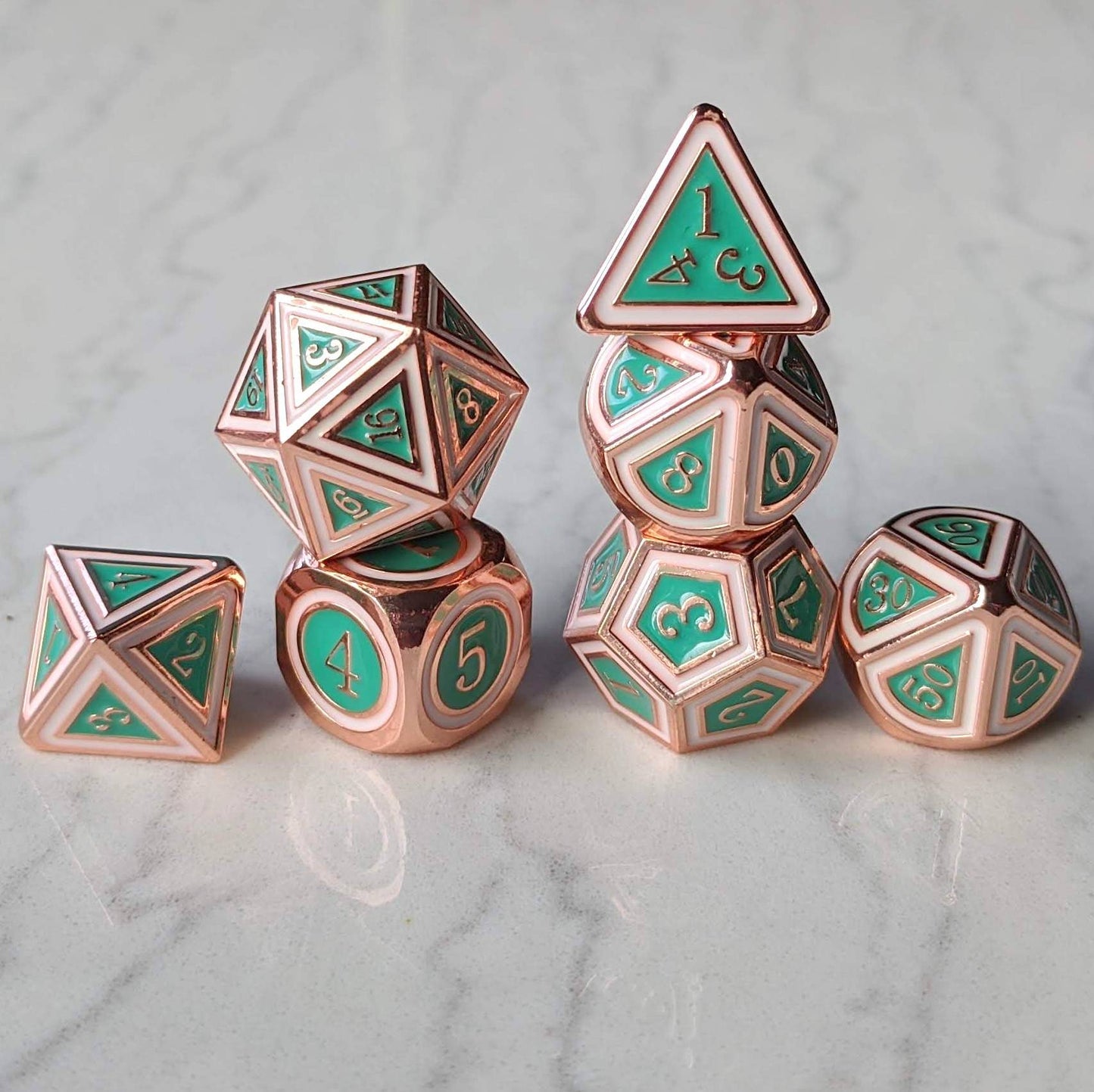 Copper plated metal dice set with turquoise green and white enamel, 7-piece polyhedral for tabletop RPGs like Dungeons and Dragons.