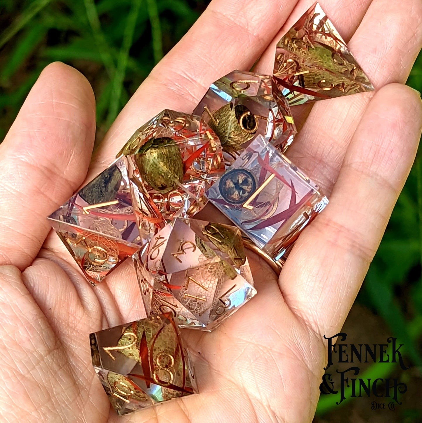 Hand holding Eucalyptus Sharp Edge Resin Dice Set with dried pods and leaves, designed for druid or ranger TTRPG players.