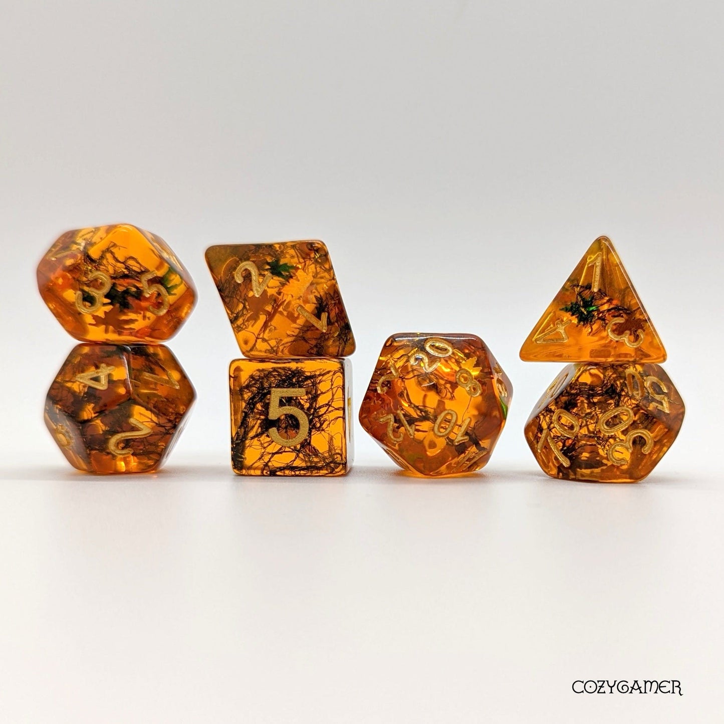 Falling Leaves DnD dice set with amber resin and autumn leaf glitter. Perfect for tabletop games like Dungeons and Dragons.