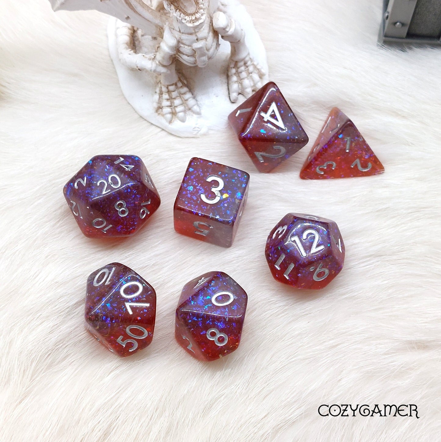 Fiery Sparkle Dice Set with glitter, 7-piece polyhedral dice for DnD and tabletop RPGs, featuring red and purple colors.