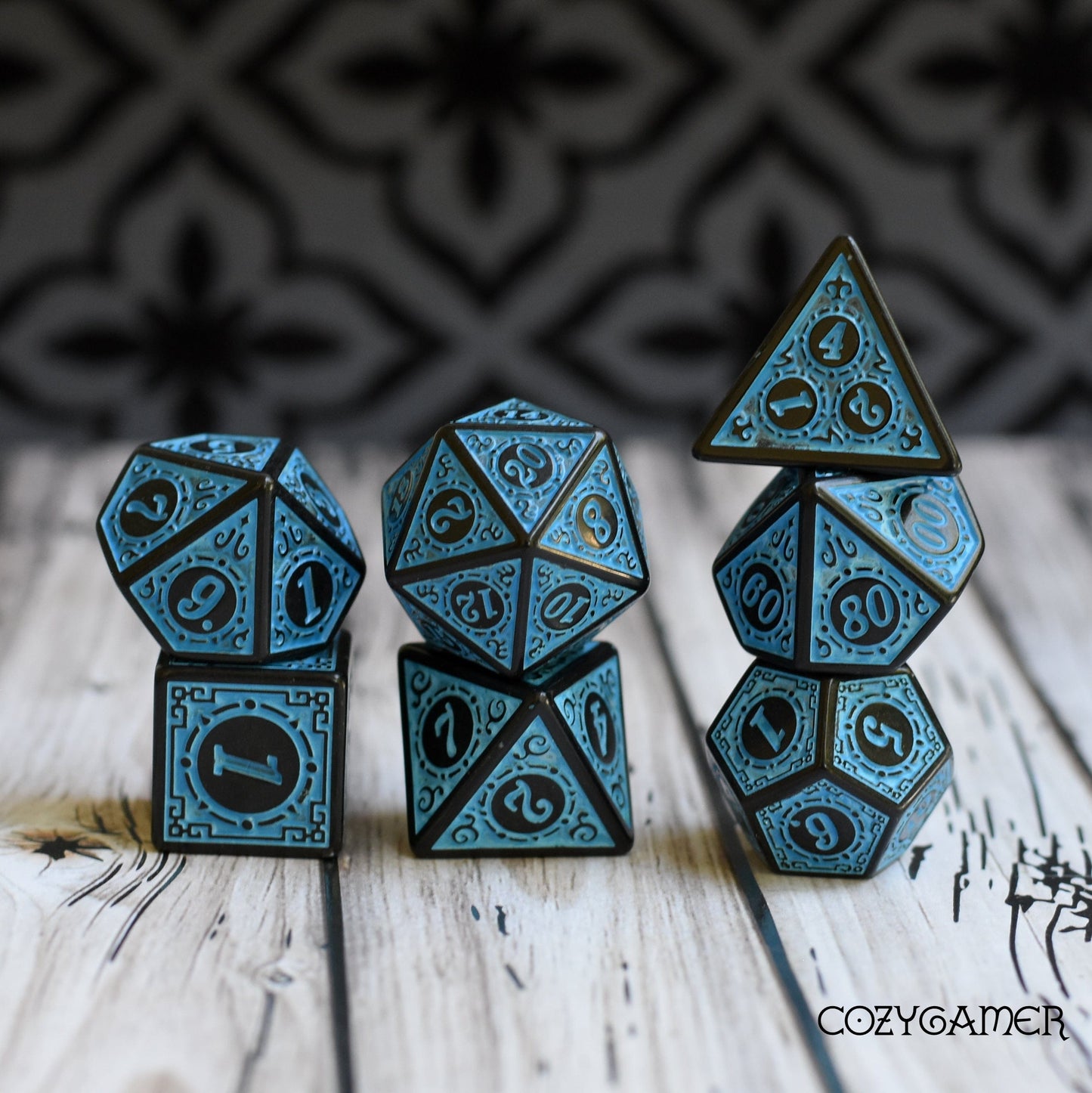 Filigree Framed Dice Set, 7-piece polyhedral design for Dungeons & Dragons and Magic The Gathering, displayed on a wooden table.