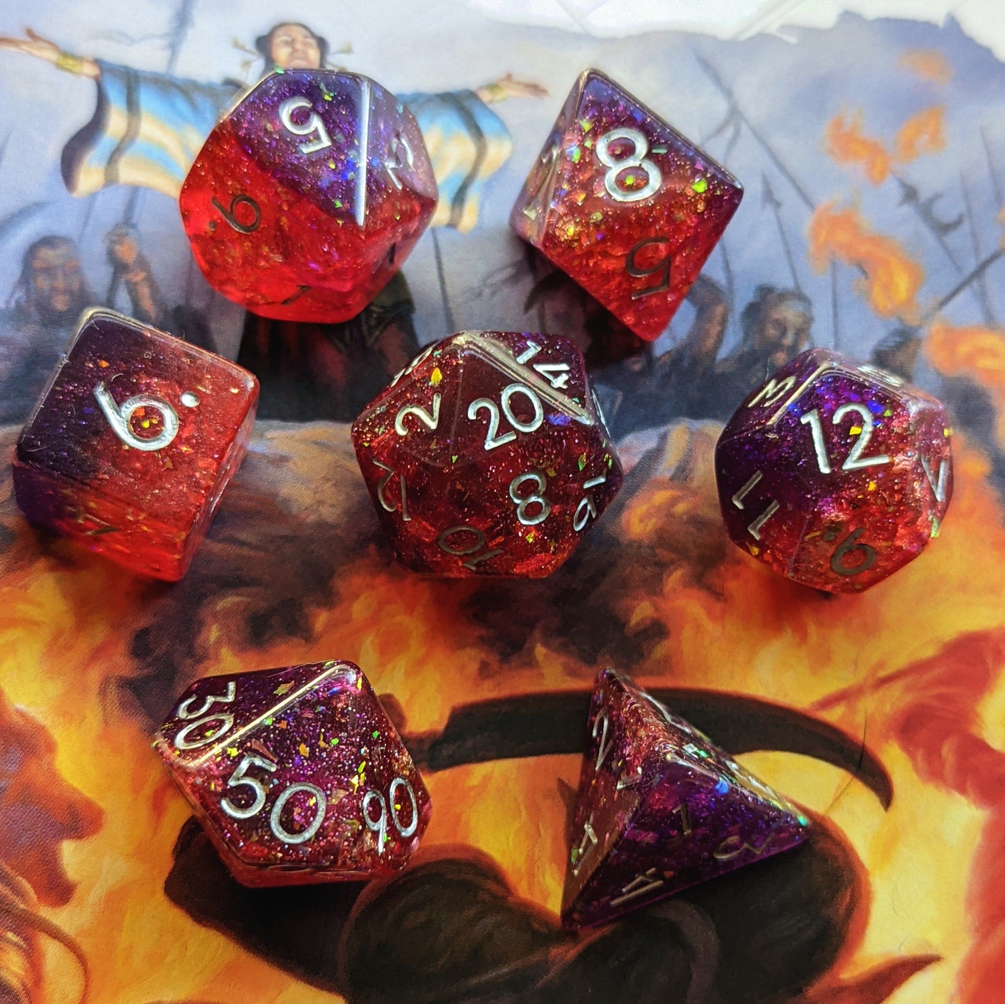 Gambit Dice Set with red and purple opal flakes and gold foil on fiery backdrop, perfect for Dungeons and Dragons or TTRPG gaming.