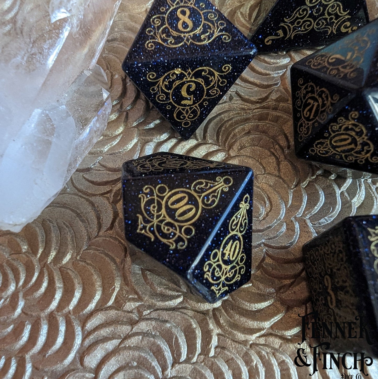 Garden Gate Blue Sandstone Gemstone Dice Set with gold numbers on a textured surface.