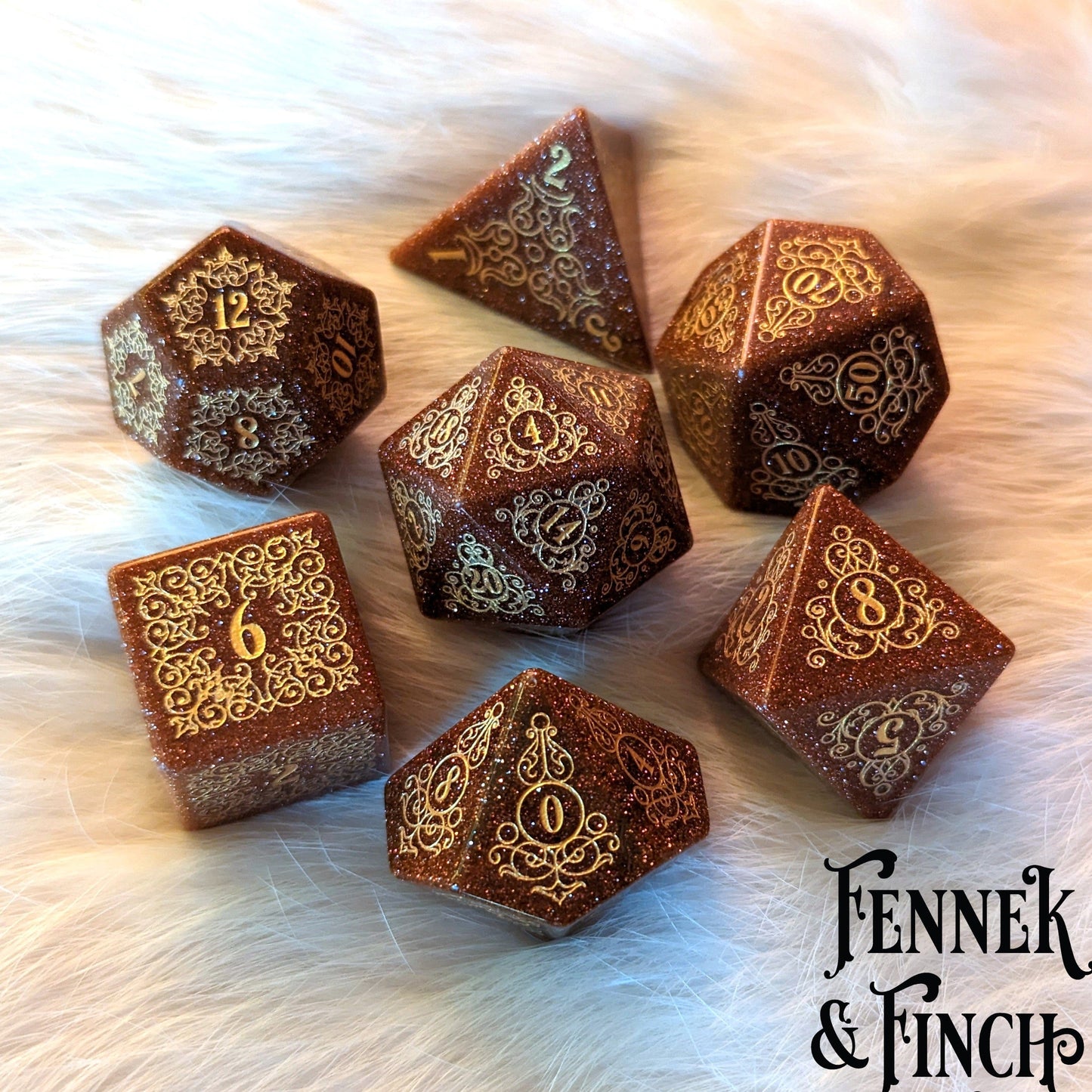 Garden Gate Goldstone Gemstone Dice Set with floral and swirl designs on a furry background