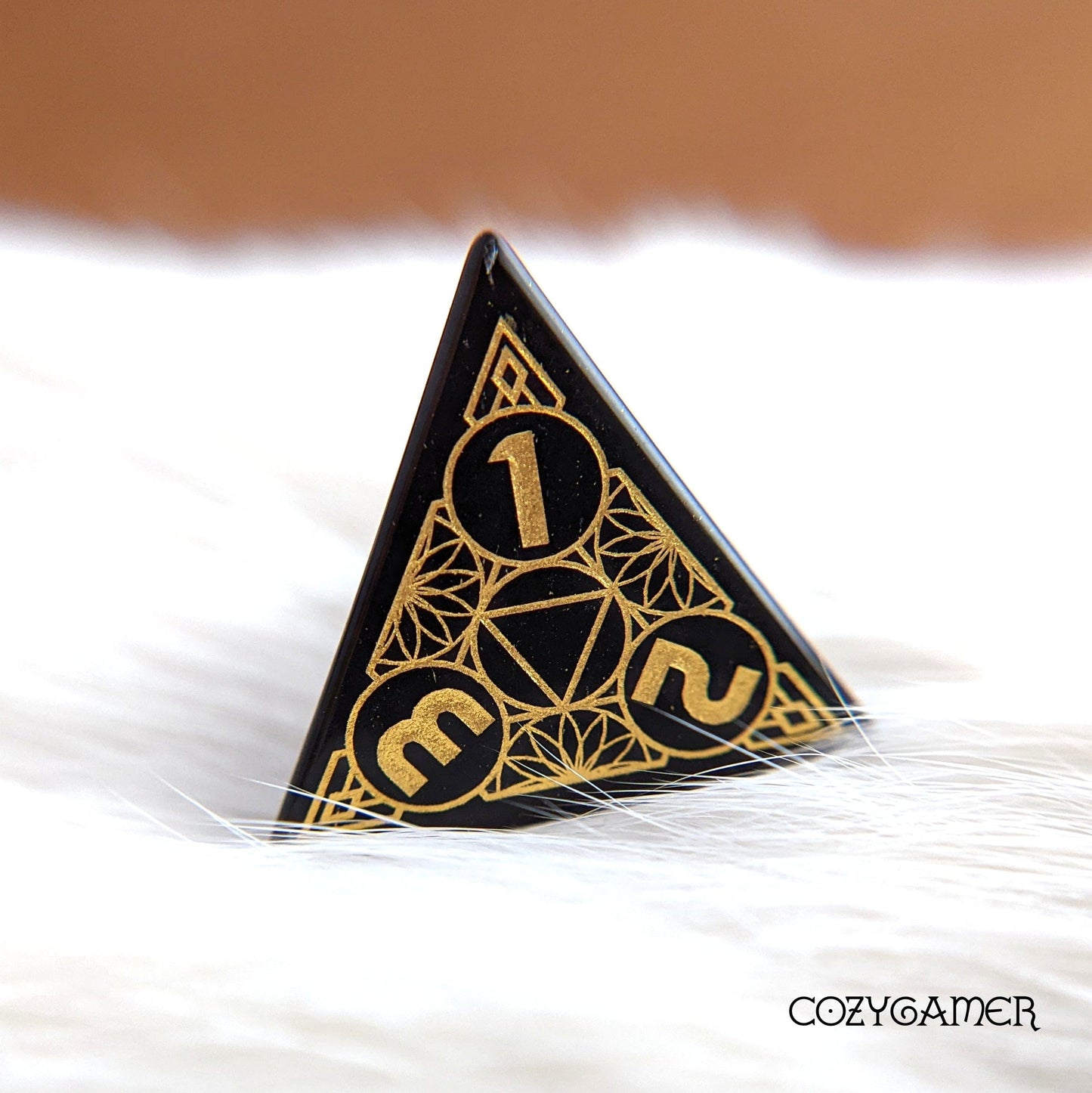 Geometric obsidian gemstone dice with gold numbers, featuring intricate design.