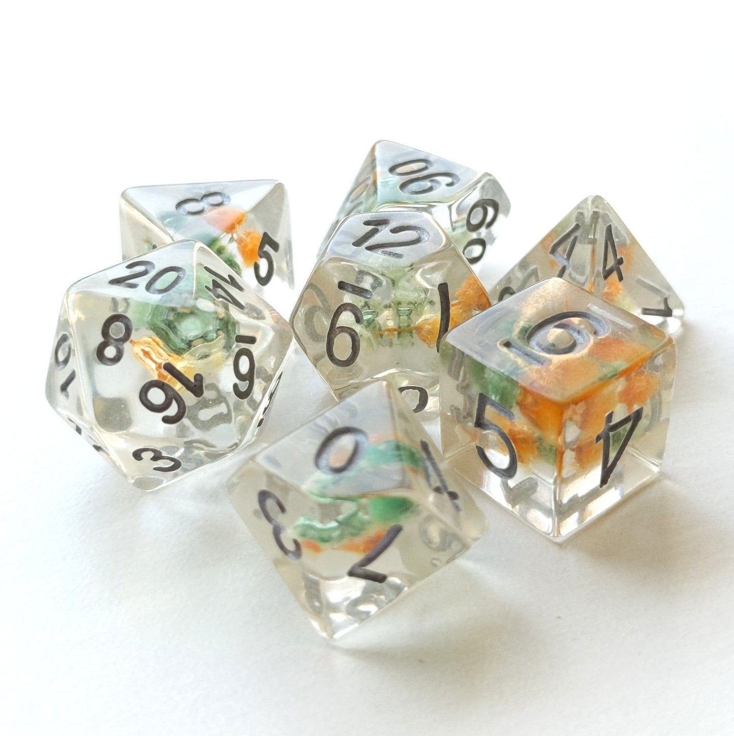 Green and orange flower dice set with real dried flowers inside, 7-piece polyhedral for DnD and TTRPG tabletop games.