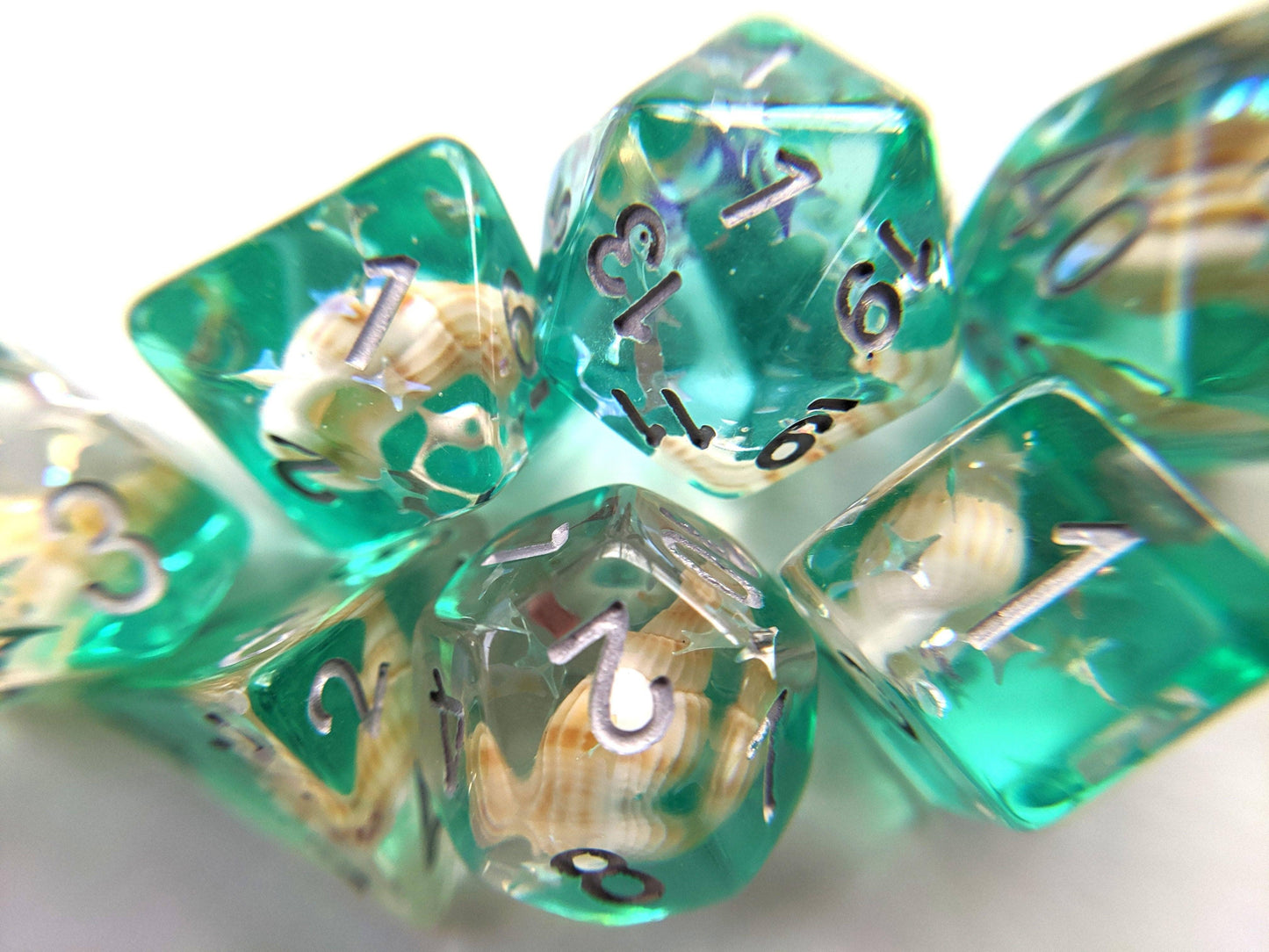 Green Conch Dice Set with seashells and glitter, ideal for tabletop RPGs.