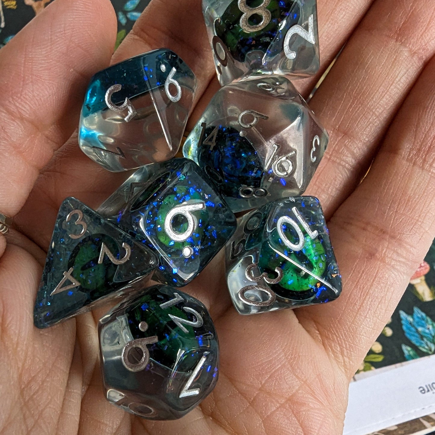 Green Eye DnD Dice Set with detailed eye inclusion on blue layer, 7-piece polyhedral set for tabletop role-playing games.