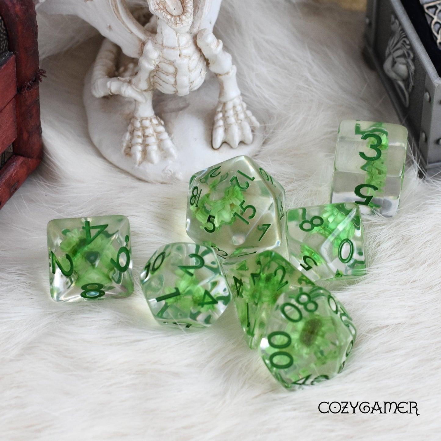 Green Mini Flower Dice Set with dried flowers, 7-piece polyhedral for DnD, displayed on furry surface.