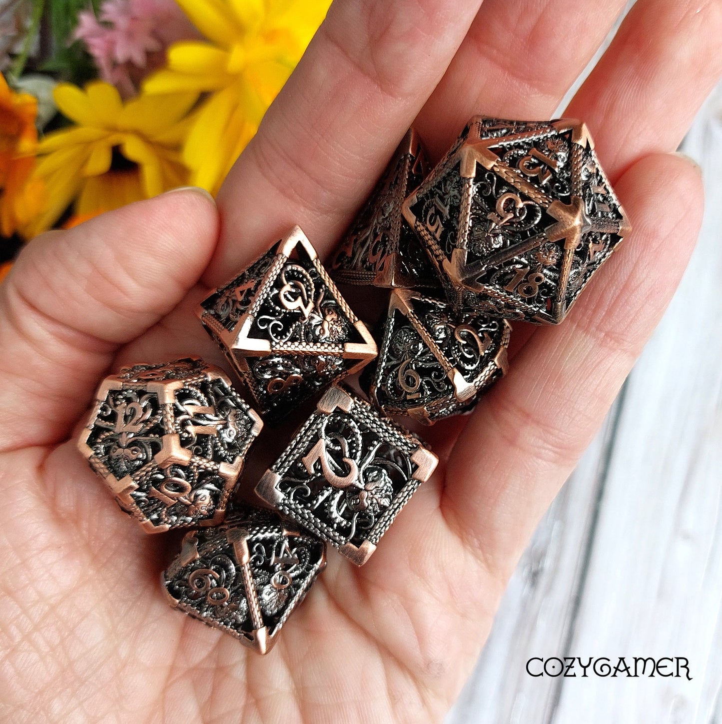 Hand holding Kraken Hollow Metal Dice Set for tabletop RPGs, featuring intricate kraken tentacle designs.