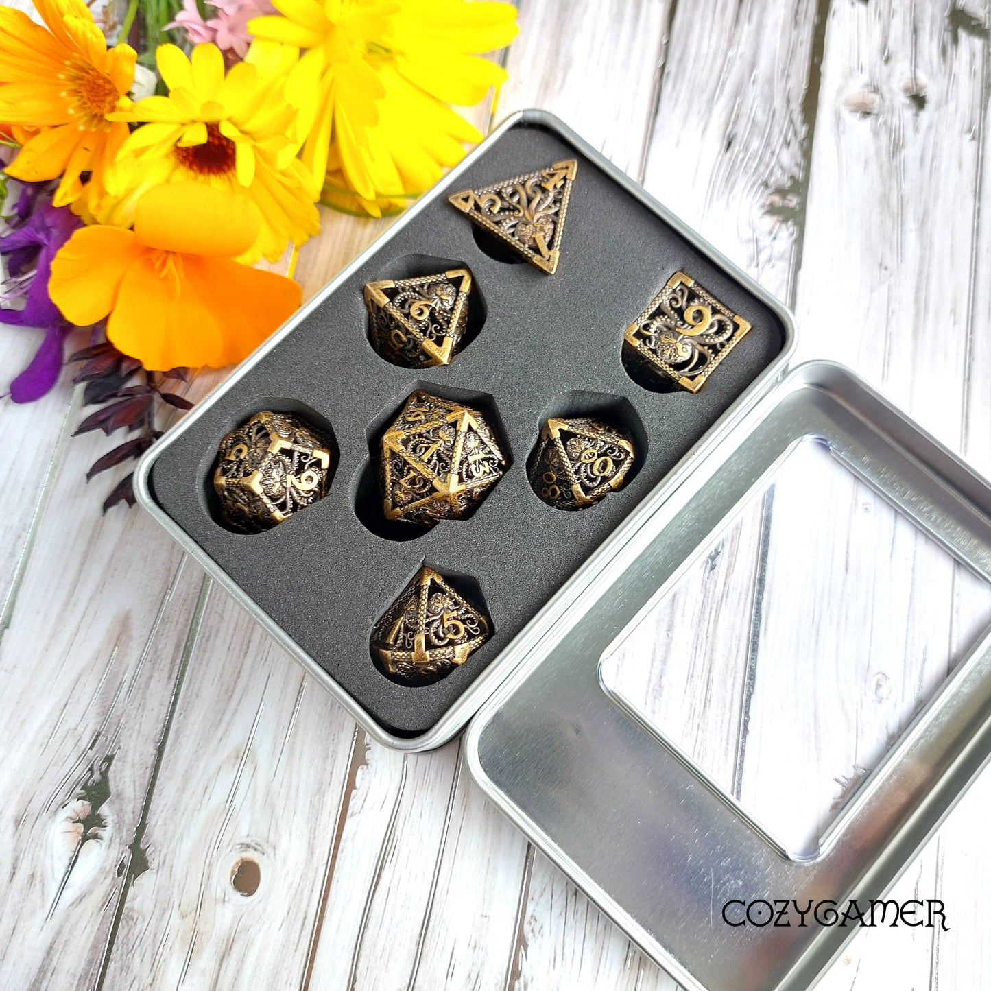 Kraken Hollow Metal Dice Set in black tray with colorful flowers in background for Dungeons and Dragons and tabletop games.