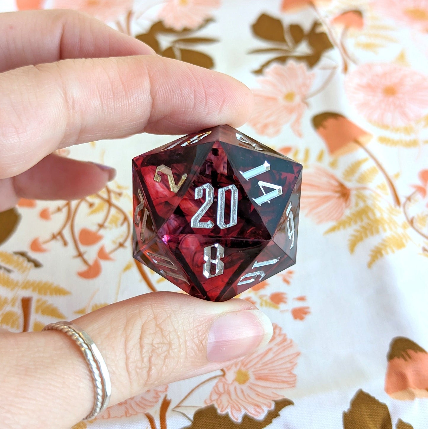 Hand holding large red resin D20 die for Dungeons and Dragons, 33mm sharp edge, perfect for tabletop role-playing games.