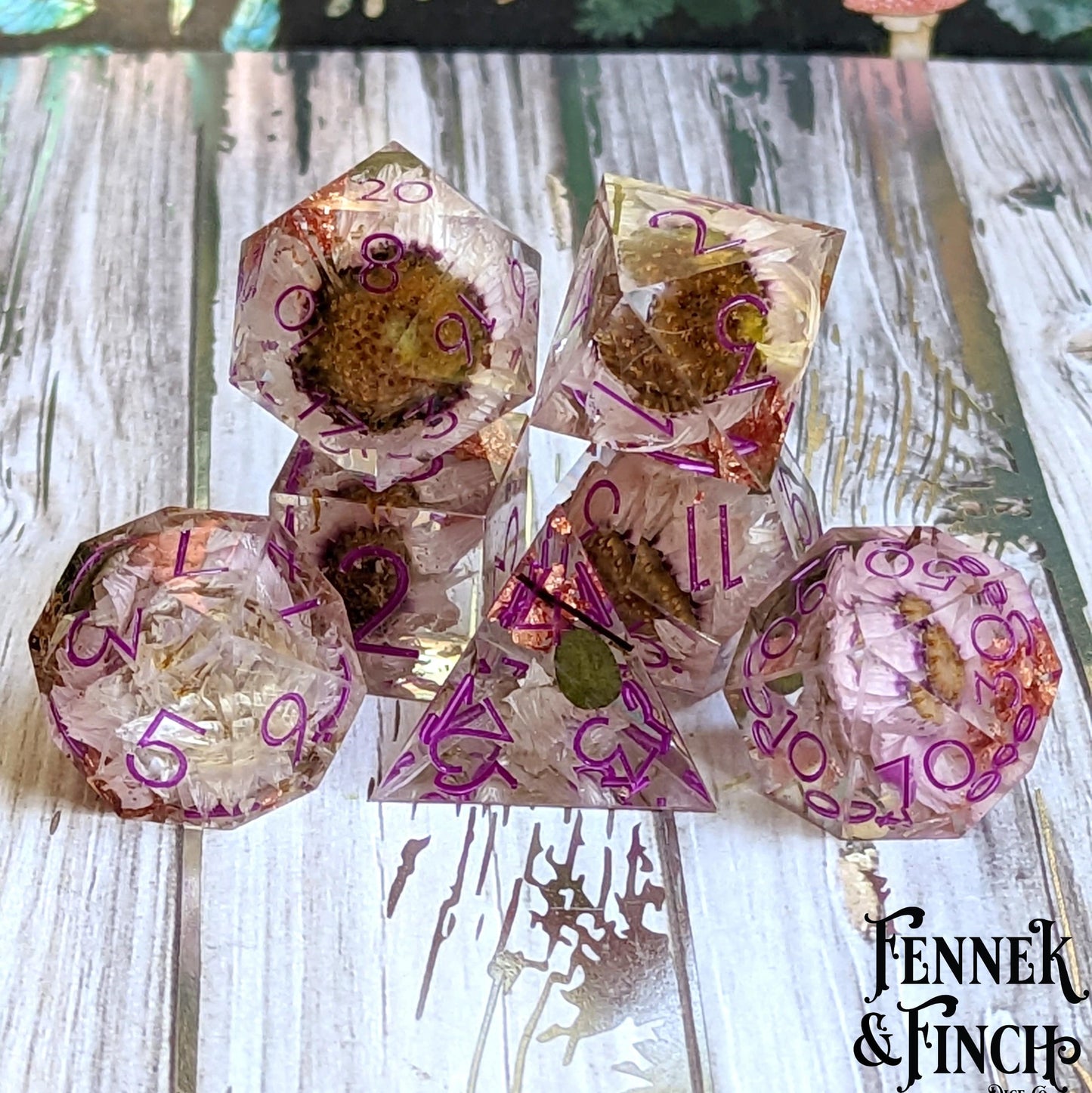 Magenta Ink Daisy Sharp Edge DnD Dice Set with daisies and copper foil, featuring glass-like resin finish on a wooden tabletop.