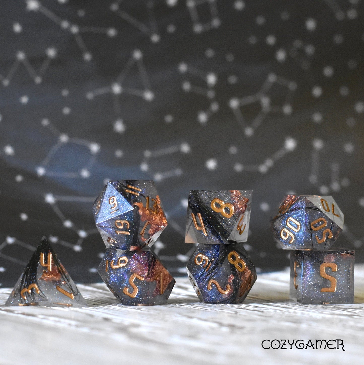 Magic Feather Dice Set with black feathers and copper foil, ideal for Dungeons and Dragons games, displayed with a starry background.