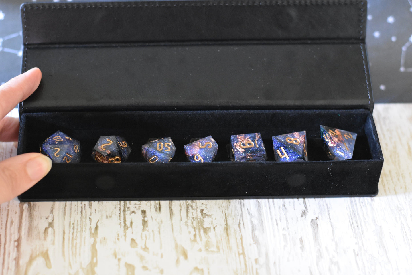 DnD dice set with black feathers and copper foil in a black case, featuring sharp edge resin design and glitter accents.