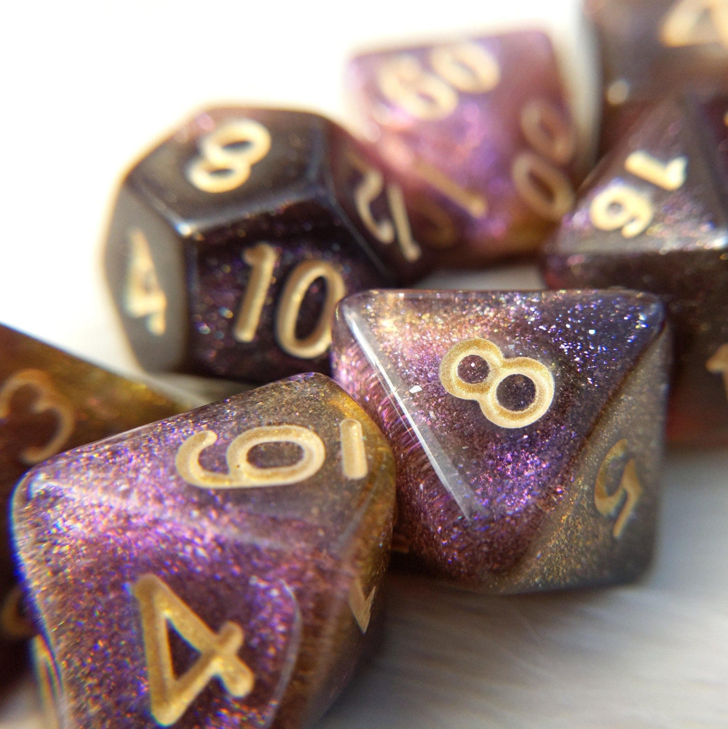 Purple, yellow, and brown shimmer polyhedral dice set with gold numbers for tabletop RPGs like Dungeons and Dragons.