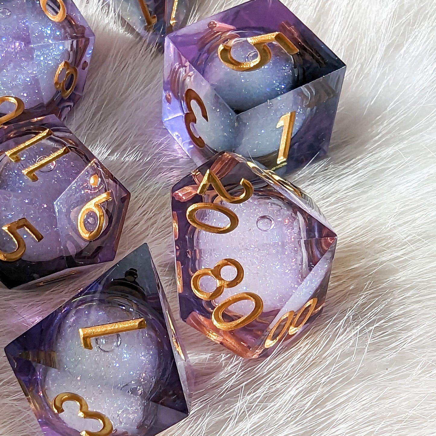 Purple and black liquid core DnD dice set with micro shimmer, featuring sharp edges and gold numbers on a fluffy surface.