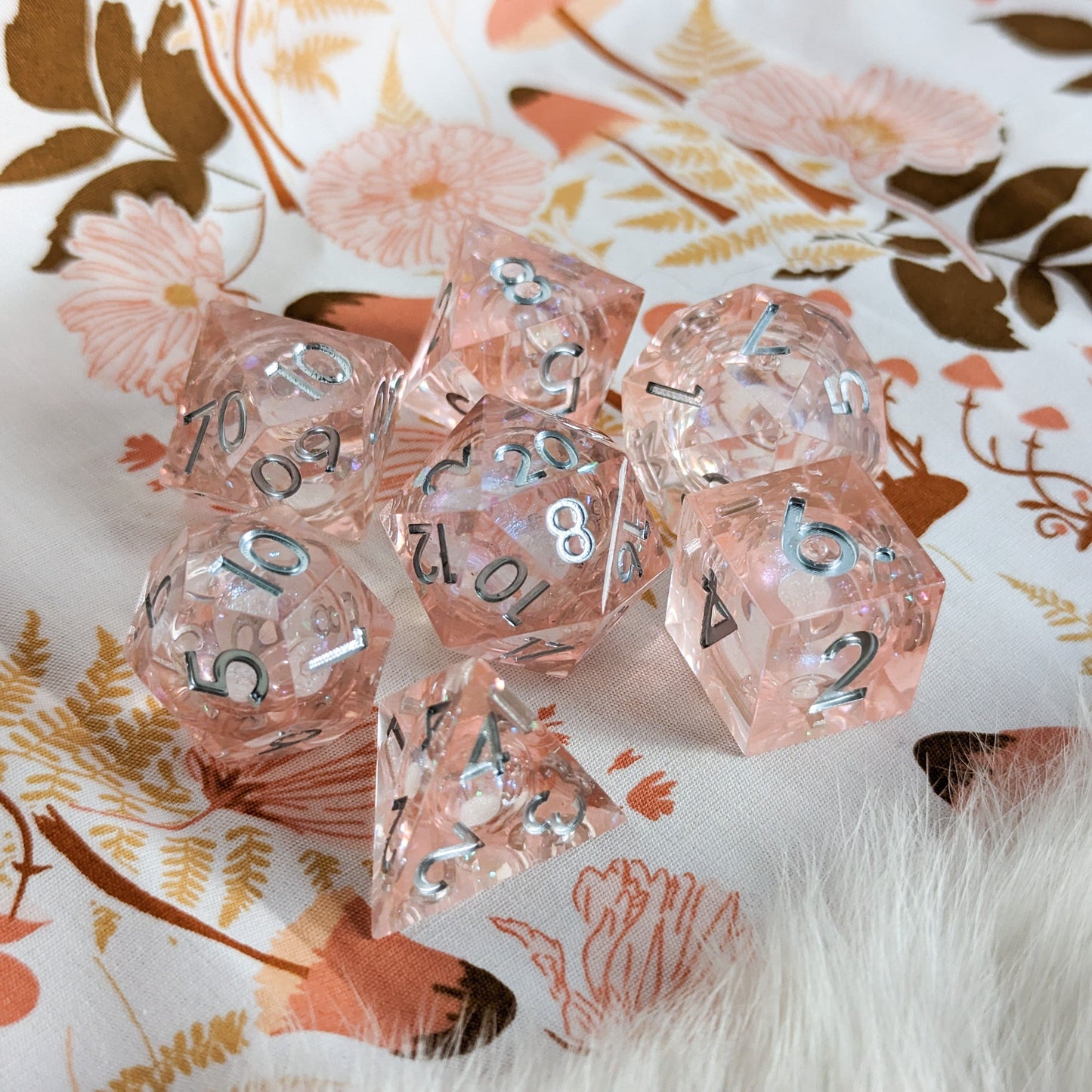 Peach liquid core resin dice set with sharp edges and micro shimmer, ideal for Dungeons and Dragons tabletop games.