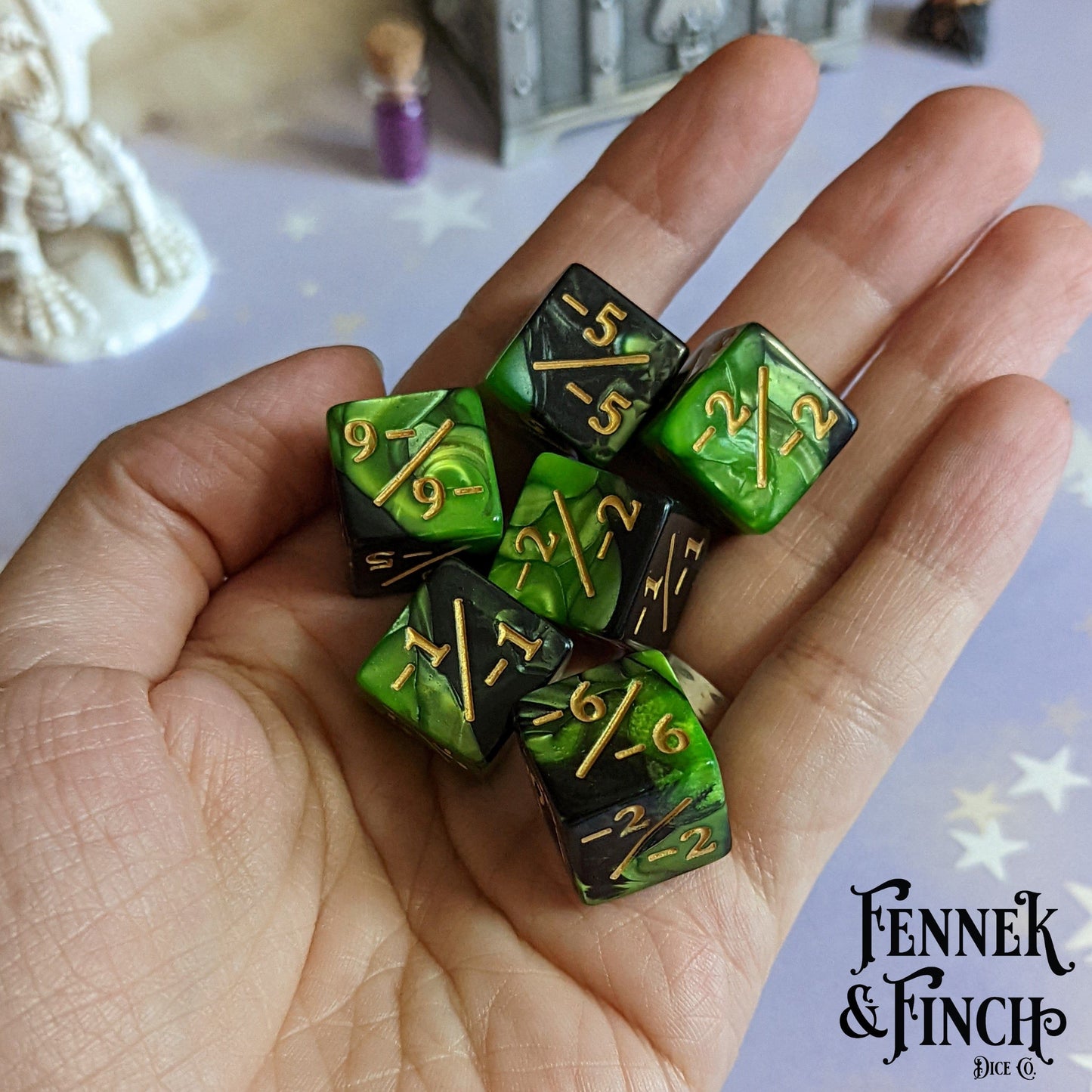 Set of 6 pearly green and black acrylic negative D6 counter dice in hand, featuring gold numbers, standard 16mm size.