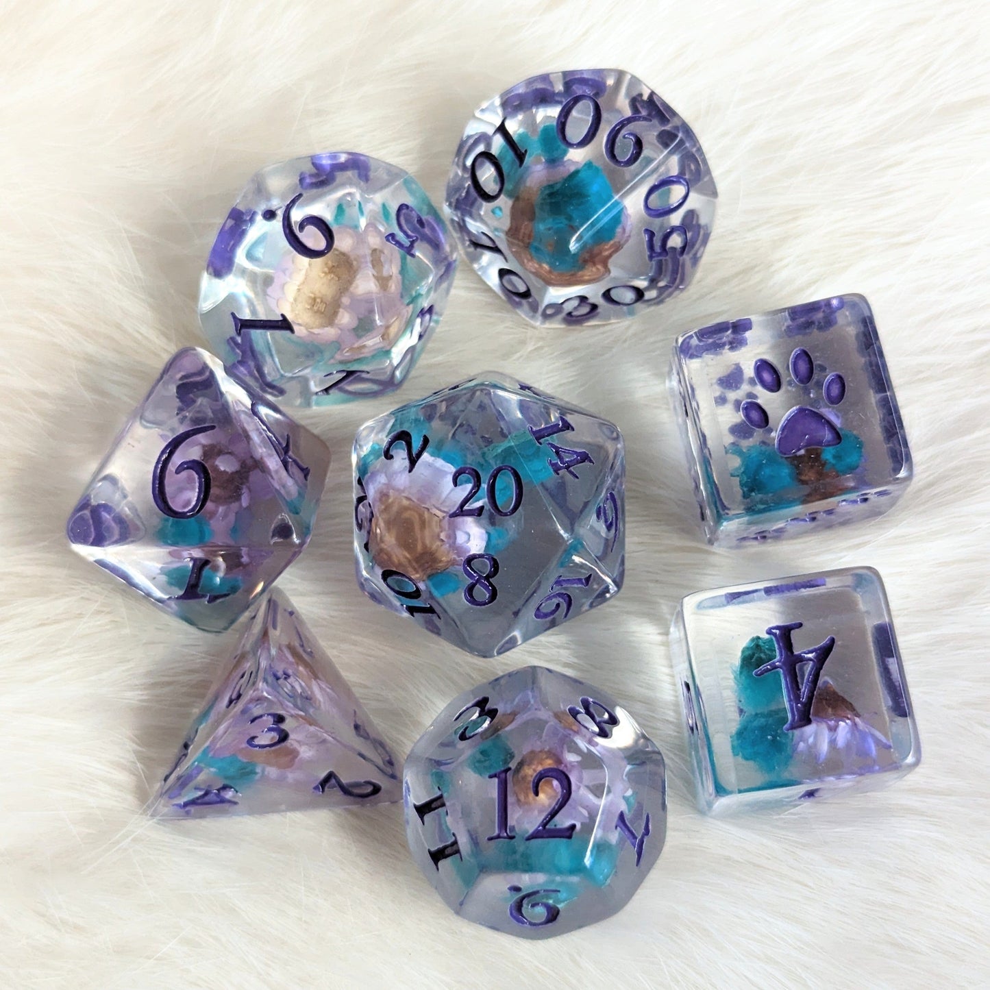 Purple and blue flower DND dice set with unique designs, including extra D6 with paw prints and fantasy font, perfect for TTRPGs.