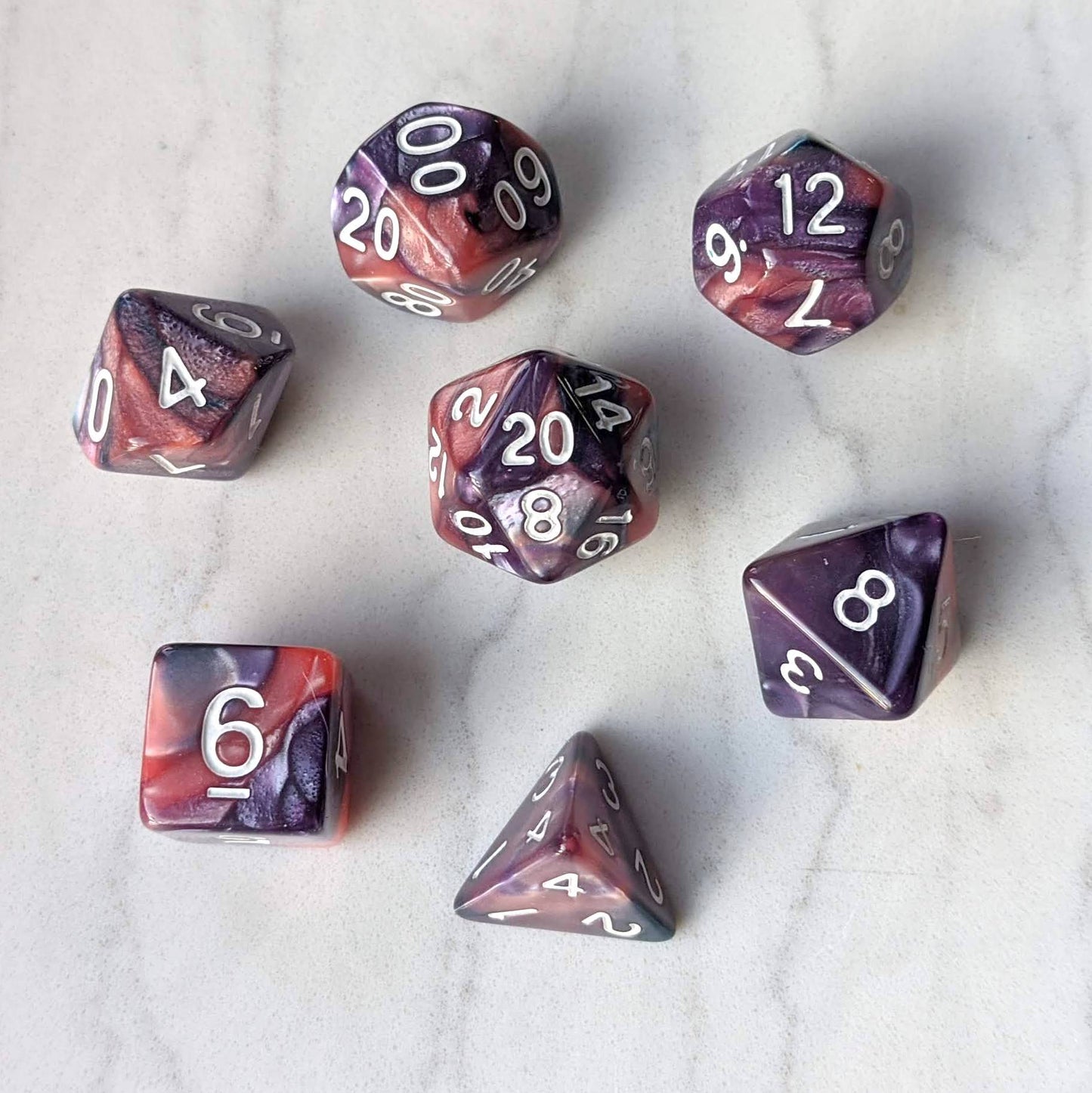 Purple and rose pearly marbled dice set for tabletop RPGs, featuring white numbers.
