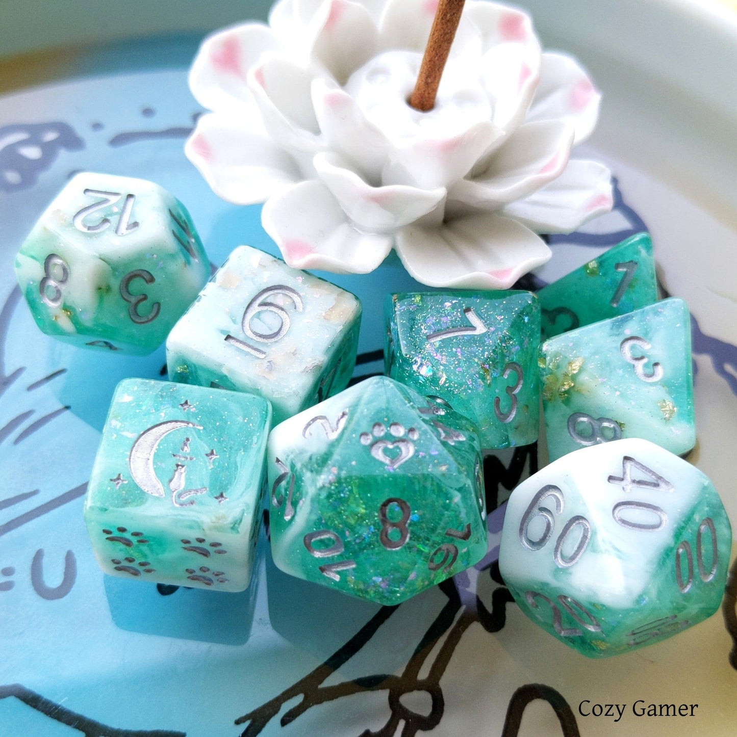 Seafoam 8-piece dice set in clear teal and white marble with glitter and foil, featuring custom cat wizard and paw designs.