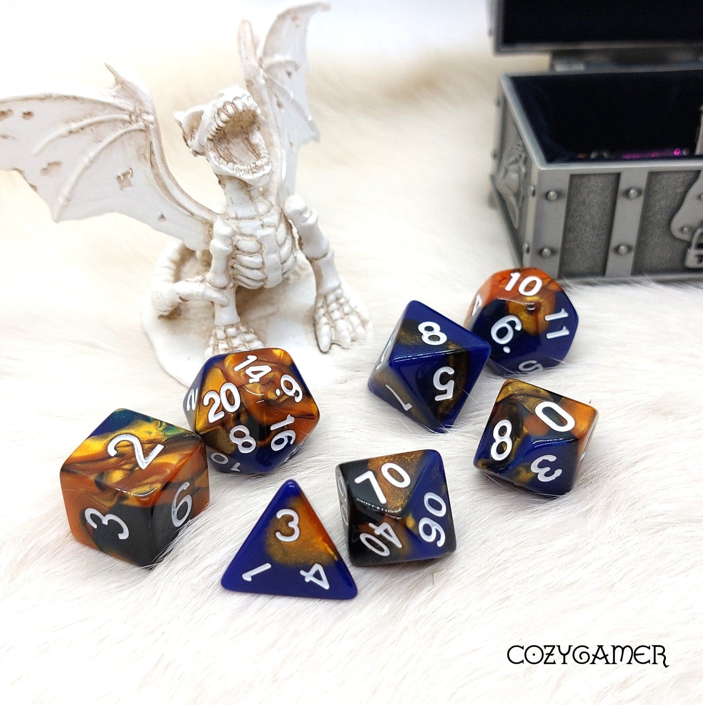 Searing Comet DnD dice set with blue, black, and gold marble design, perfect for tabletop RPGs, displayed with dragon figurine.