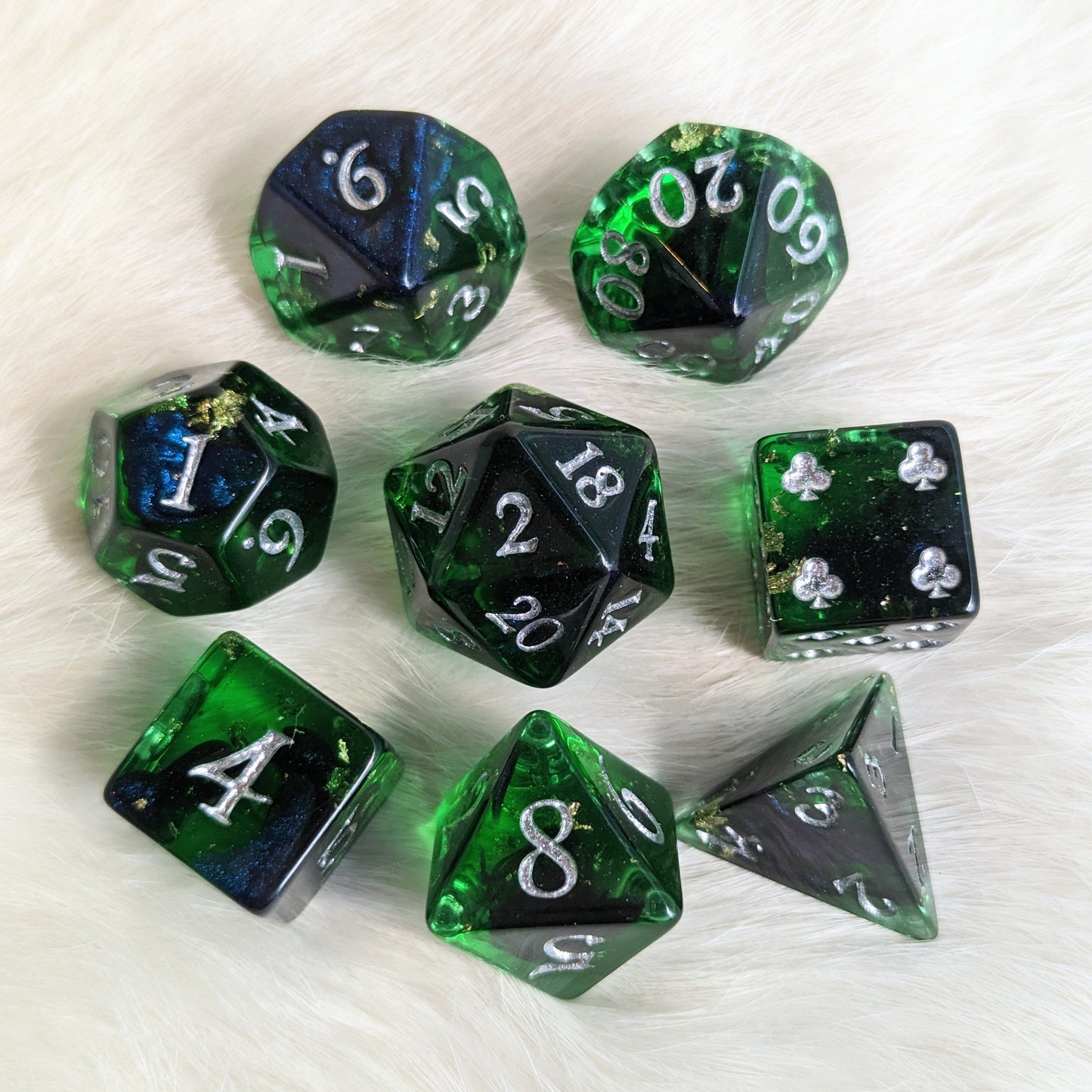Shadowy Forest DND dice set with green resin, black shadowy ink, silver numbers, and clover design on extra D6, 8 pieces in total.