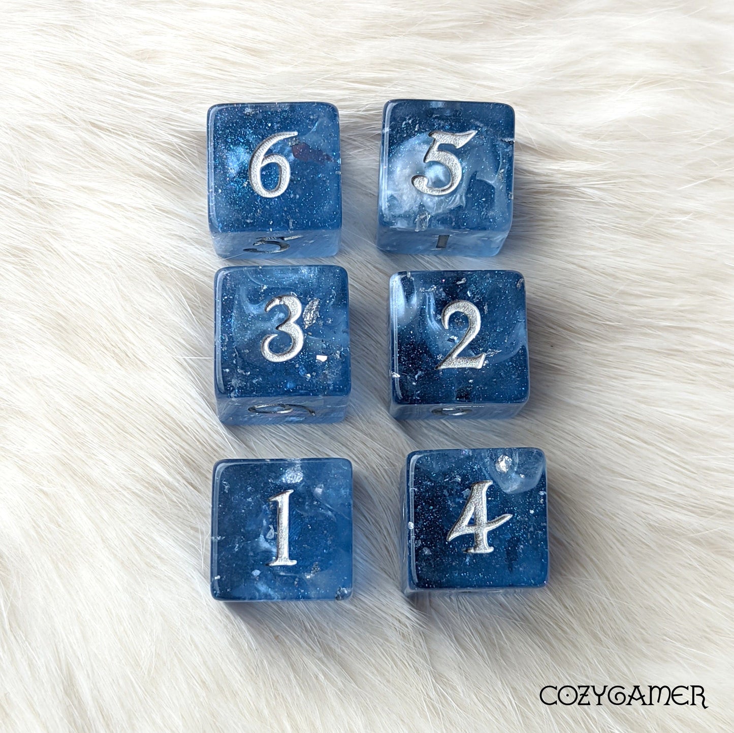 Storm Daddy 6D6 dice set with blue glitter and silver numbers on a white fur background.
