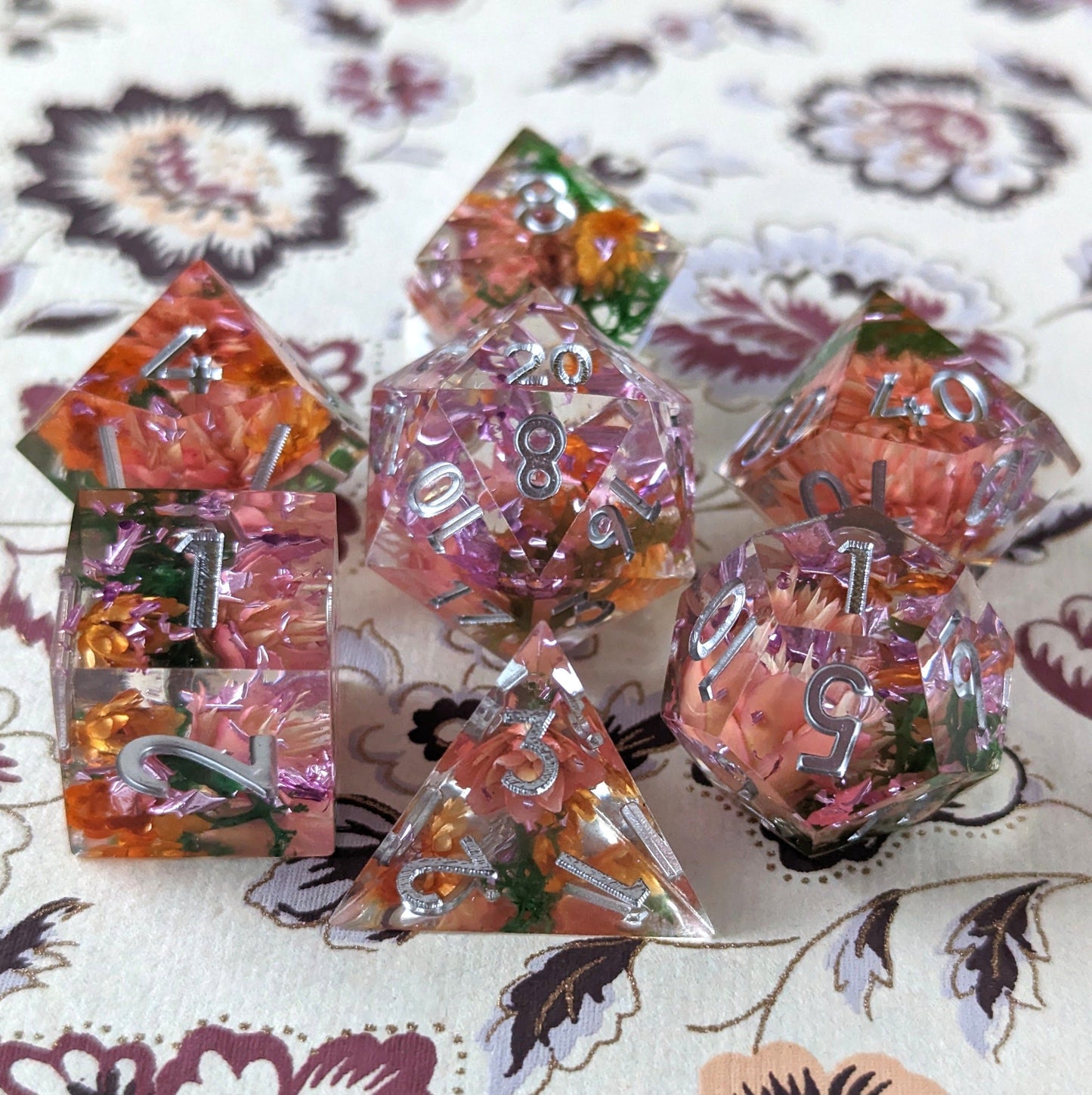 Sunny Garden DnD dice set with dried orange and pink flowers inside, featuring sharp edges and hand-finished details.