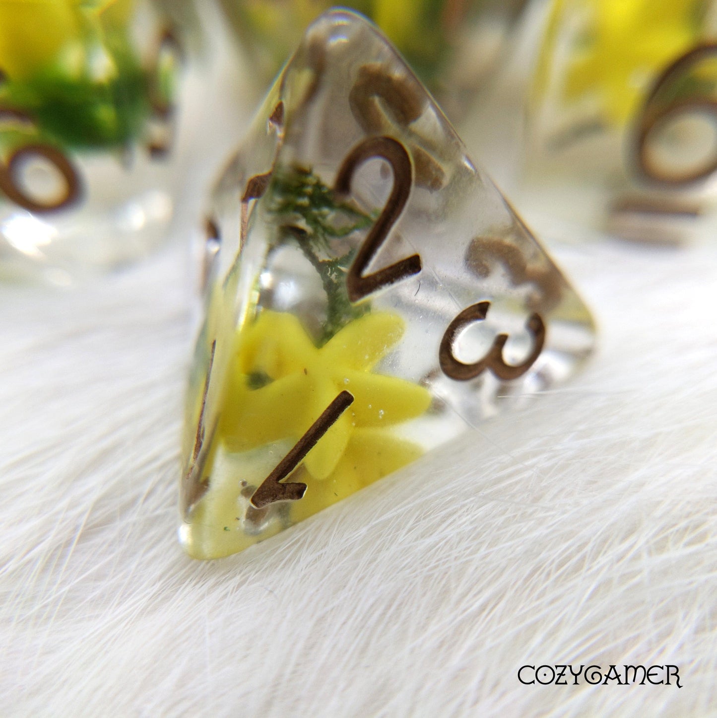 Clear D4 dice with yellow starfish and green moss inside for DnD tabletop games.