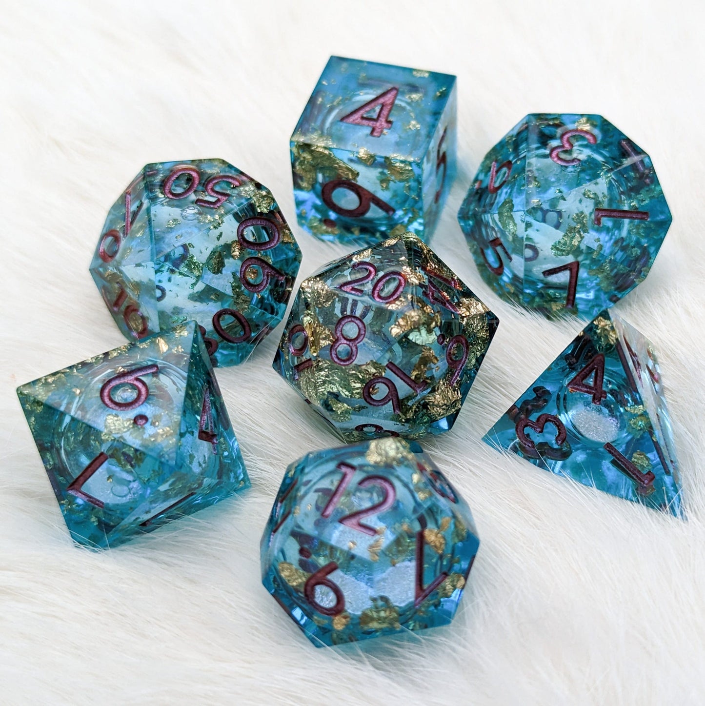 Teal and gold sharp edge liquid core resin DnD dice set with shimmer, perfect for tabletop role-playing games.