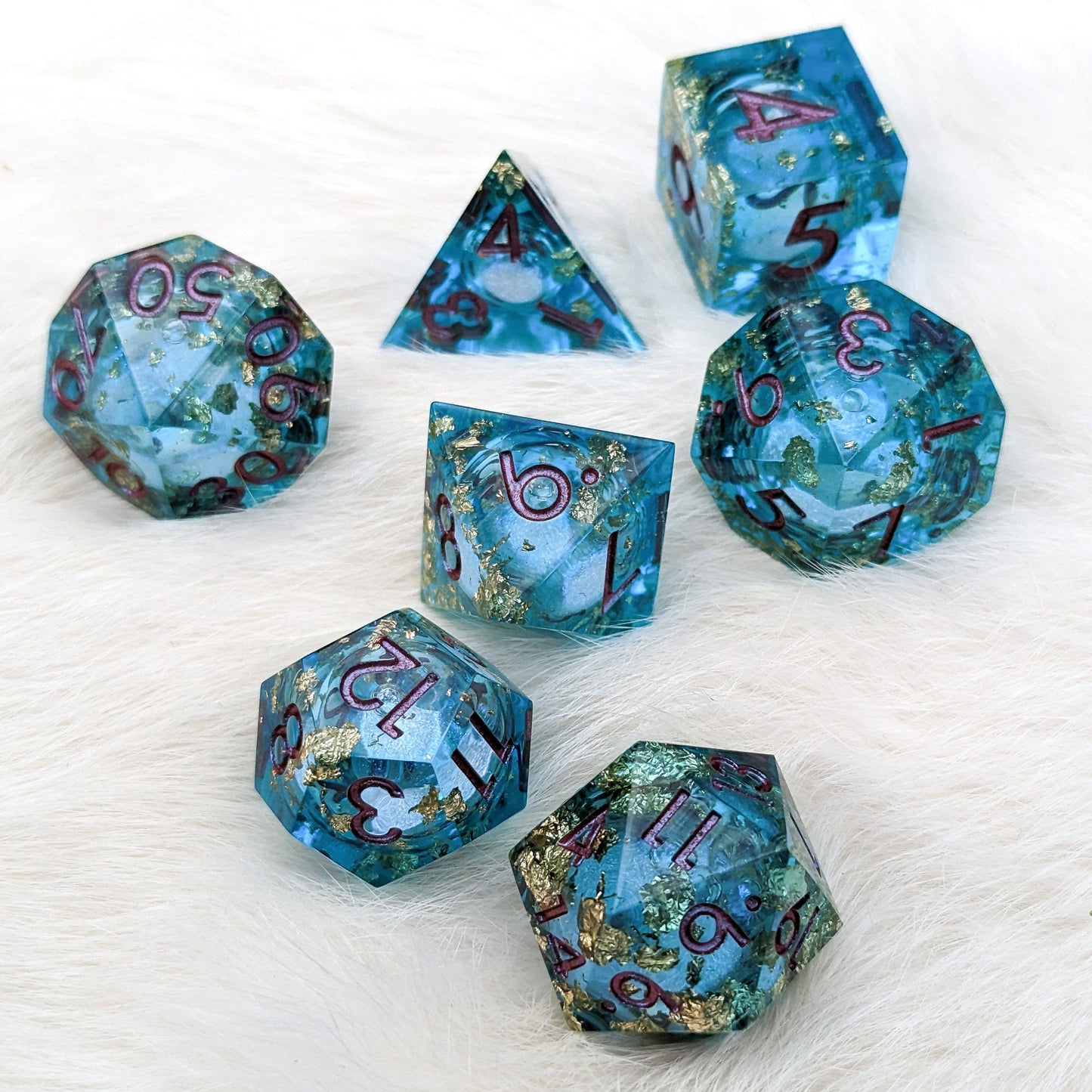 Teal and Gold Liquid Core Sharp Edge Resin DnD Dice Set on White Background
