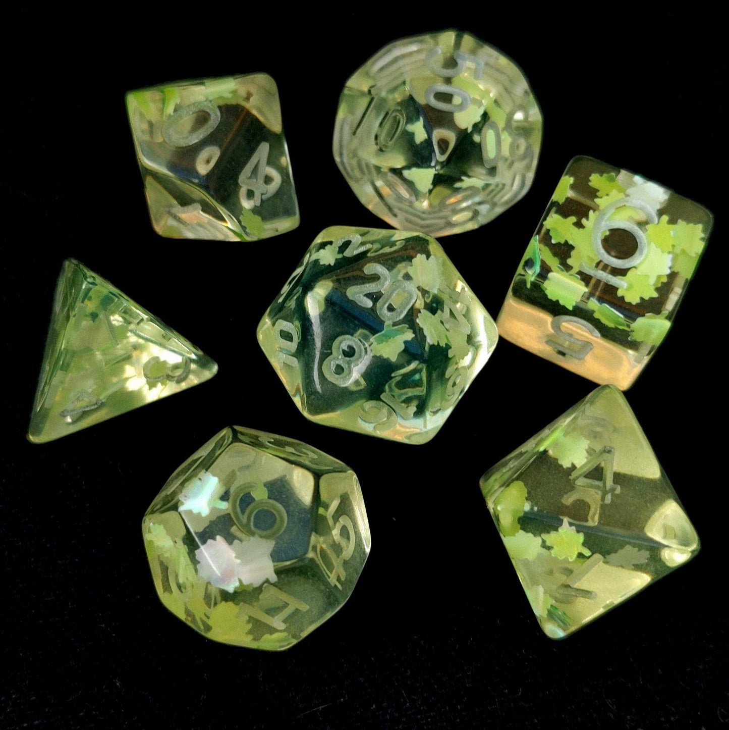Un-inked Feywild polyhedral dice set with clear resin and light green leaves, designed for tabletop RPGs like Dungeons and Dragons.