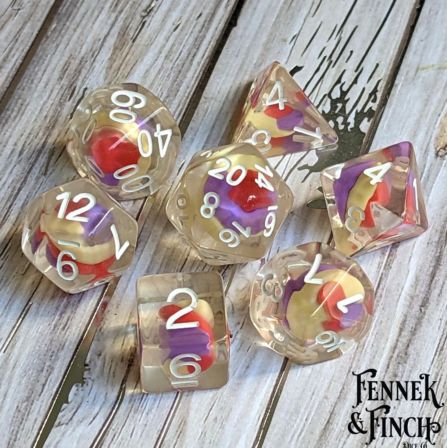 Unicorn Candy Swirl Dice Set with colorful clay candy center for tabletop RPGs, 7-piece polyhedral resin dice on wooden surface.