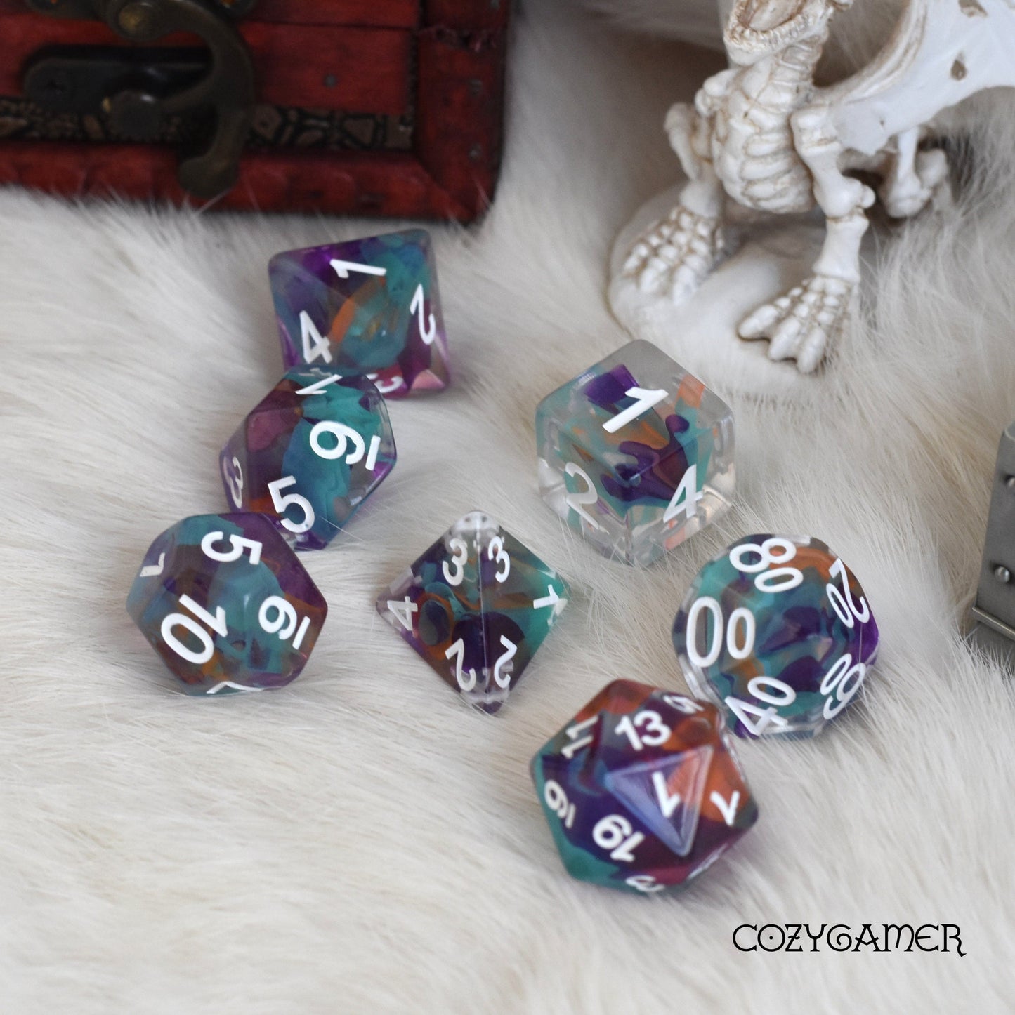Colorful Unknown Lands Dice Set for tabletop RPGs displayed on a furry surface, featuring clear resin with vibrant shavings.