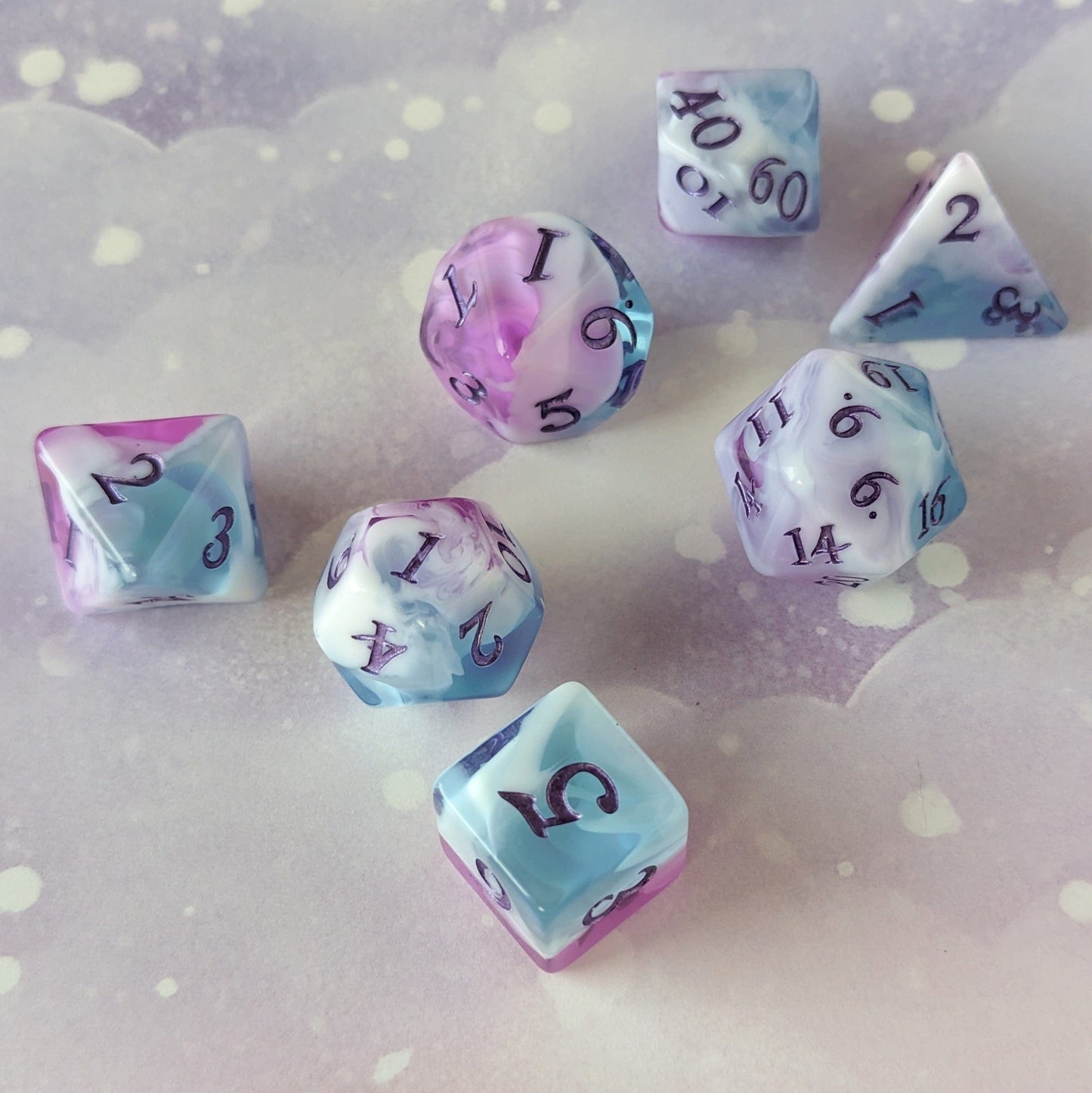 Vale of Dreams DnD dice set with marbled clear blue and purple, featuring white clouds and metallic deep purple numbers.