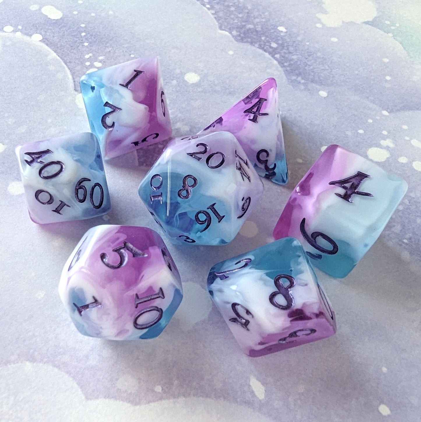 Vale of Dreams DnD dice set featuring marbled clear blue, purple, and white design with metallic deep purple numbers.