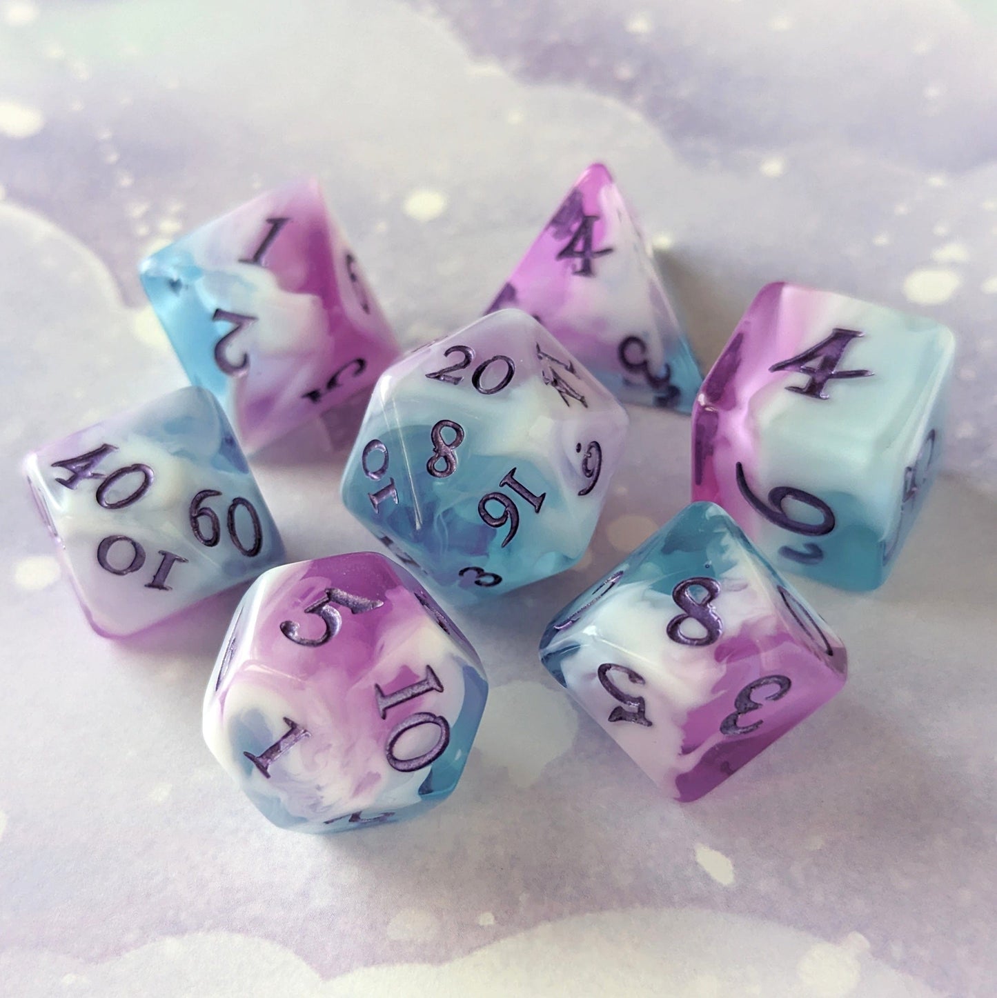 Vale of Dreams DnD dice set in marbled blue, purple, and white with deep purple numbers on a dreamy background.