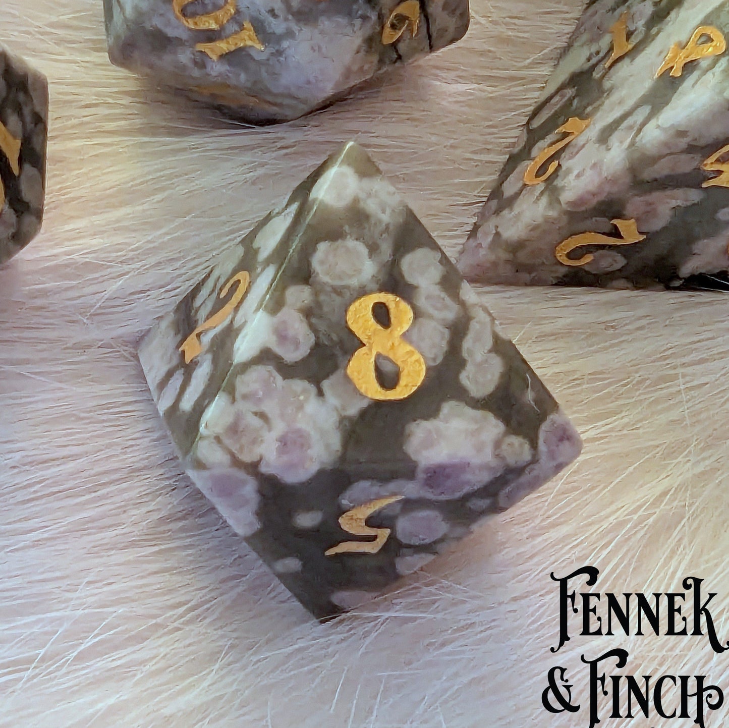 White and green jasper gemstone dice with golden numbers, part of a 7-piece TTRPG set by Fennek & Finch.