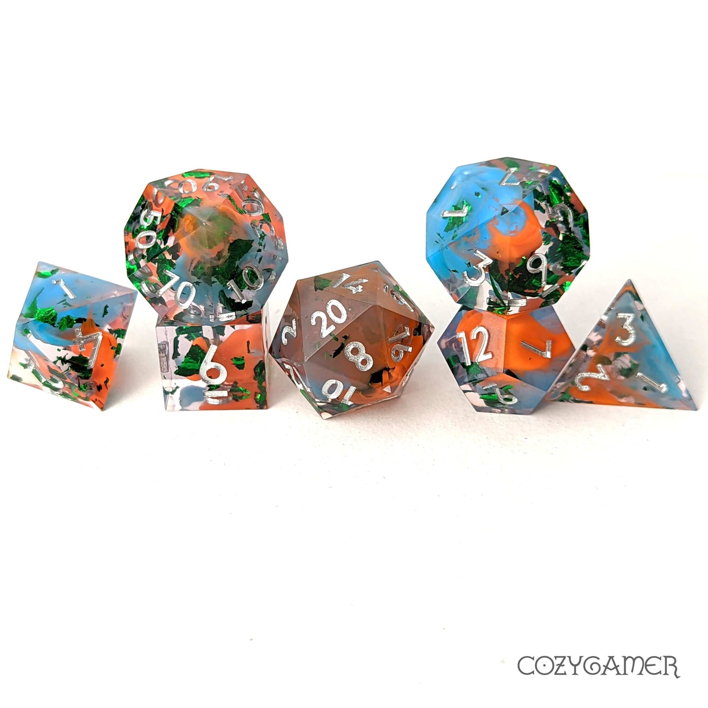 Wizard Robes sharp edge resin dice set, featuring blue and orange swirls with green metal foil glitter, 7 piece polyhedral DND set.