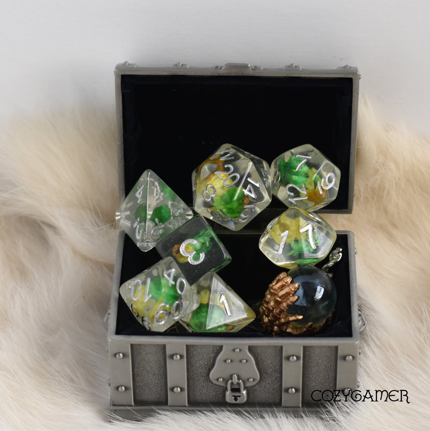 Yellow and green dried flowers dice set with silver font in a box, perfect for tabletop role-playing games like Dungeons and Dragons.